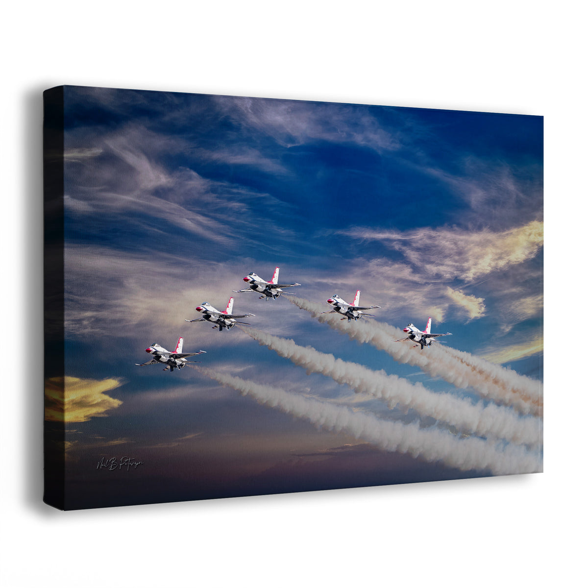 A canvas wall art print showing five USAF Thunderbird fighter jets flying in formation and leaving white smoke trails against a dramatic blue sky with clouds. The canvas is photographed at an angle on a plain white background.