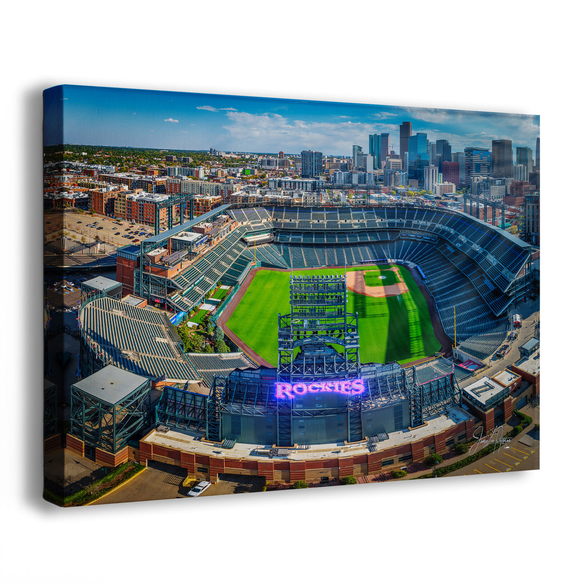 A canvas wall art print showing an aerial view of the Colorado Rockies baseball stadium with the Denver city skyline in the background, photographed on a white studio background with a slight shadow.