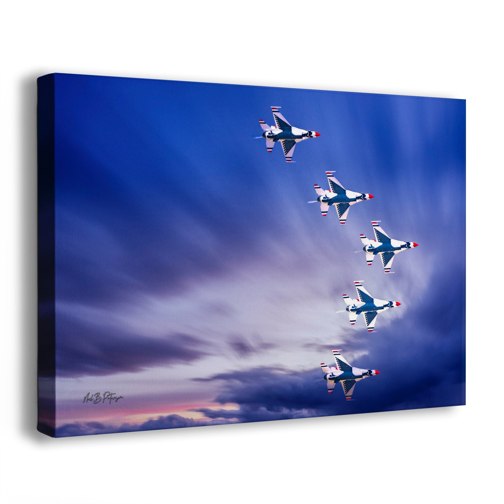 A wall art print depicting five fighter jets flying in a V formation against a dramatic blue-and-purple sky with clouds. The print is photographed at a slight angle on a clean white background.