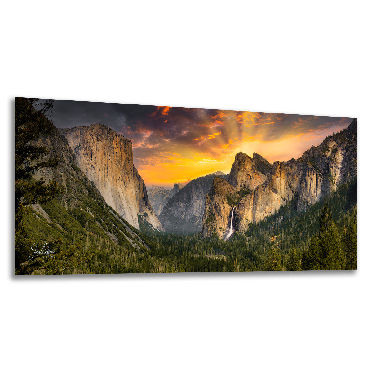 A panoramic Yosemite wall art print depicting a dramatic mountain-valley landscape at sunrise from Tunnel View, with glowing orange and yellow clouds, dark rocky peaks, and a small waterfall, set against a plain white background.