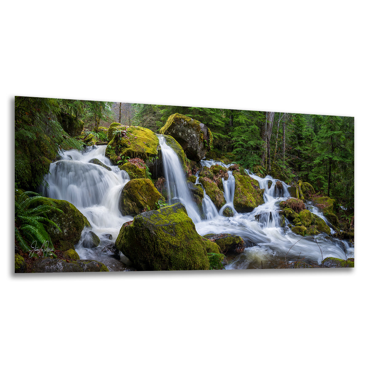 A rectangular wall art print showing a forest waterfall cascading over moss-covered rocks, displayed against a plain white background.