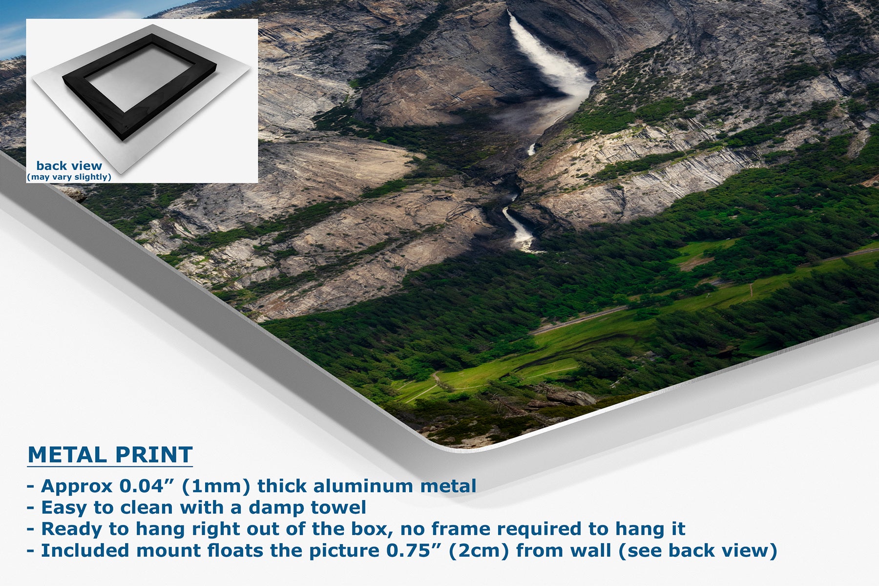 A large wall art print showing a mountain valley landscape with green fields and a waterfall, presented at an angle with a white corner fold. A small inset shows the back view of the print with a black frame.