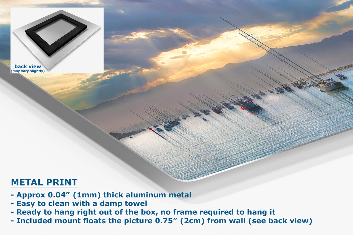 A metal wall art print showing a scenic harbor sunset with boats on the water, presented at an angle with product details and text overlays. The text highlights the product as a 'METAL PRINT' made of thick aluminum, with a small inset showing the back view of the frame.