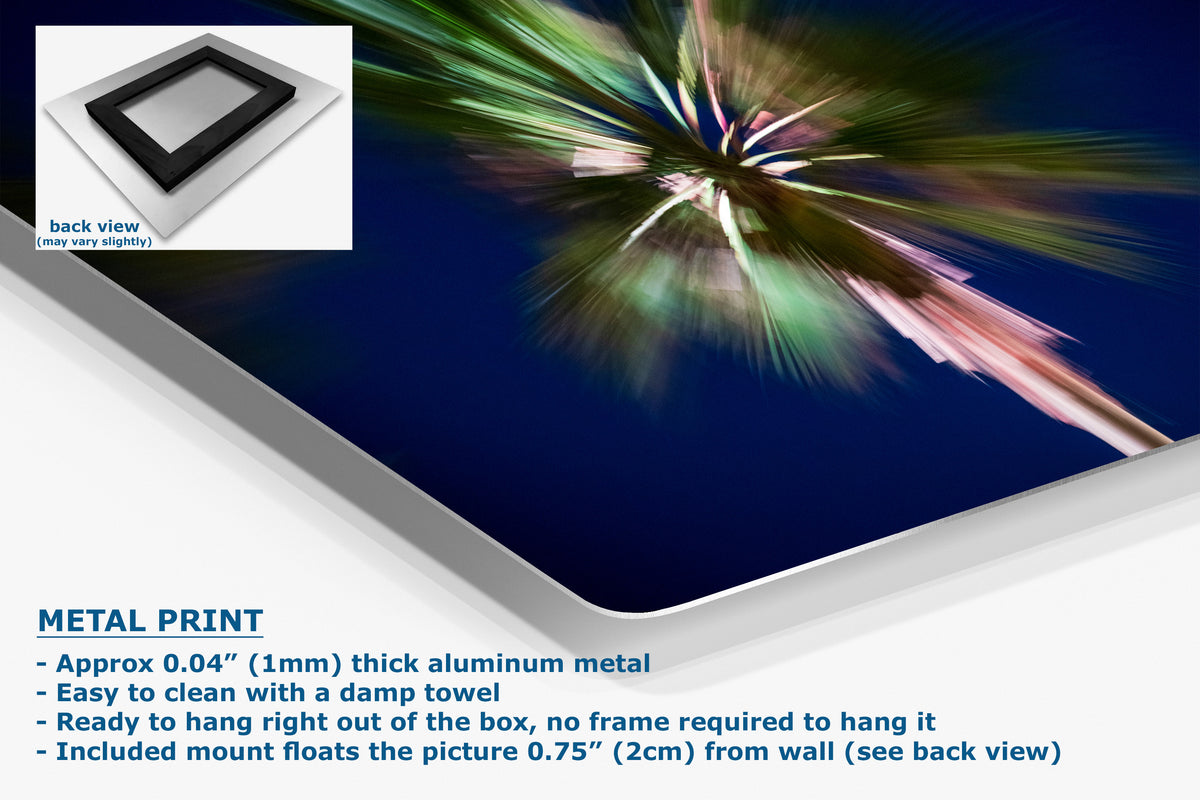 A corner view of an aluminum metal wall art print, with a small inset showing the back view of the frame. The artwork features a dark blue background with a burst of green, white, and pink abstract streaks.