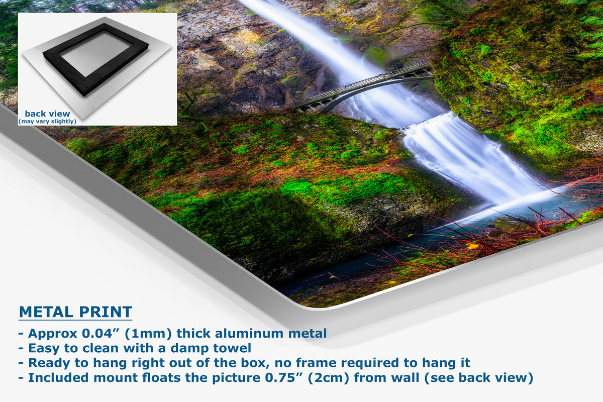 A large rectangular wall art print showing a waterfall landscape over a mossy green rocky cliff, presented at an angle with a small inset back-view swatch and descriptive text about the metal print.