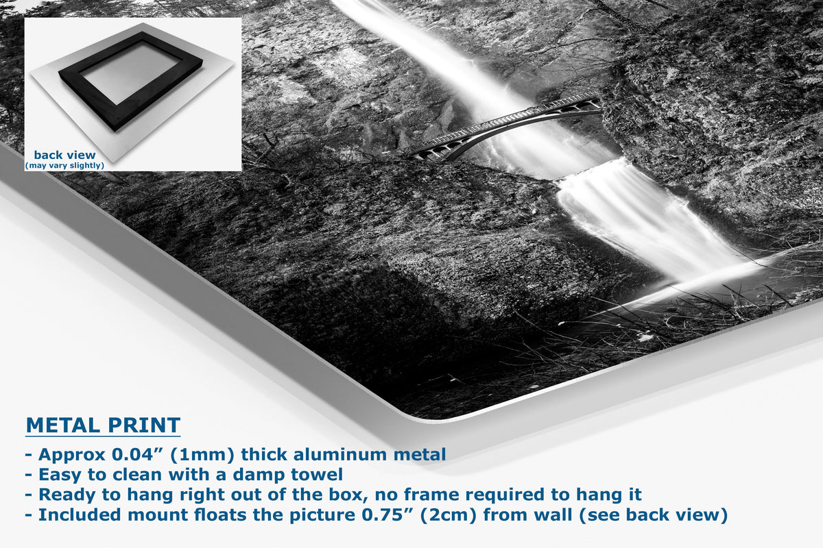 A large rectangular wall art print showing a black-and-white waterfall scene, displayed at an angle with a small inset back view of the frame mount. Text on the image reads 'METAL PRINT' and describes the aluminum print, hanging, and included mount.