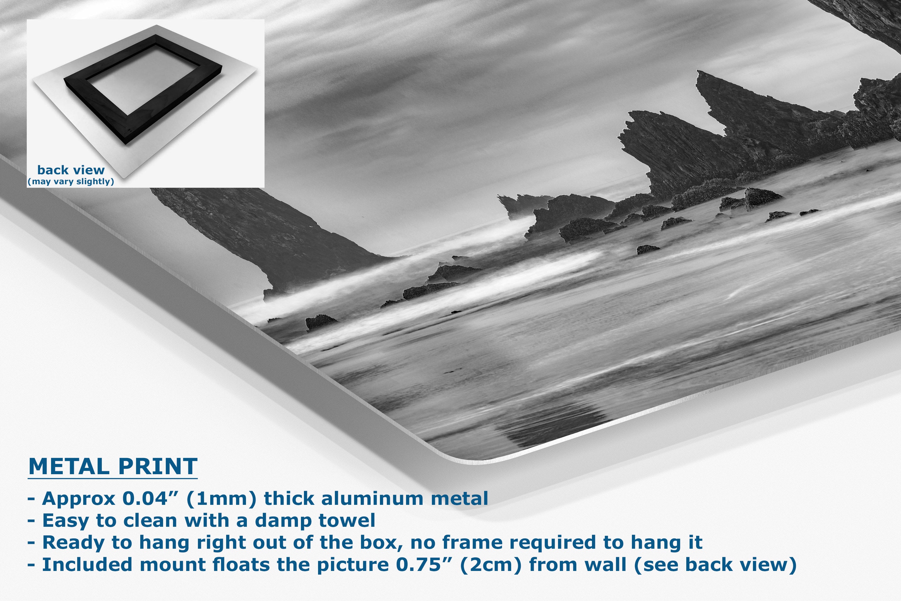 A metal wall art print showing a black-and-white coastal landscape with rocky cliffs and water, displayed at an angle on a white background with product text and a small back-view inset.