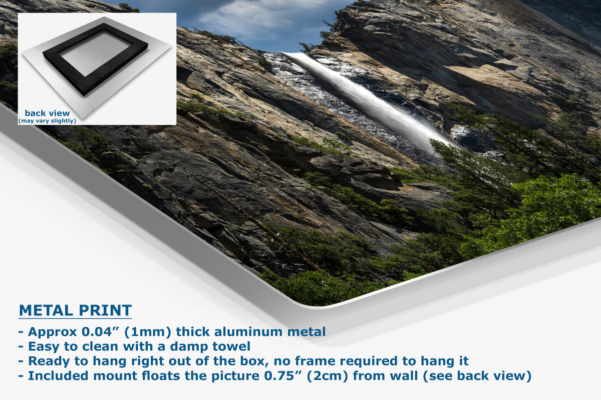 A corner view of a metal wall art print featuring a scenic waterfall cascading down a rocky mountain cliff, shown at an angle with product details and text overlays on a white background. Includes a small inset showing the back view of the frame.