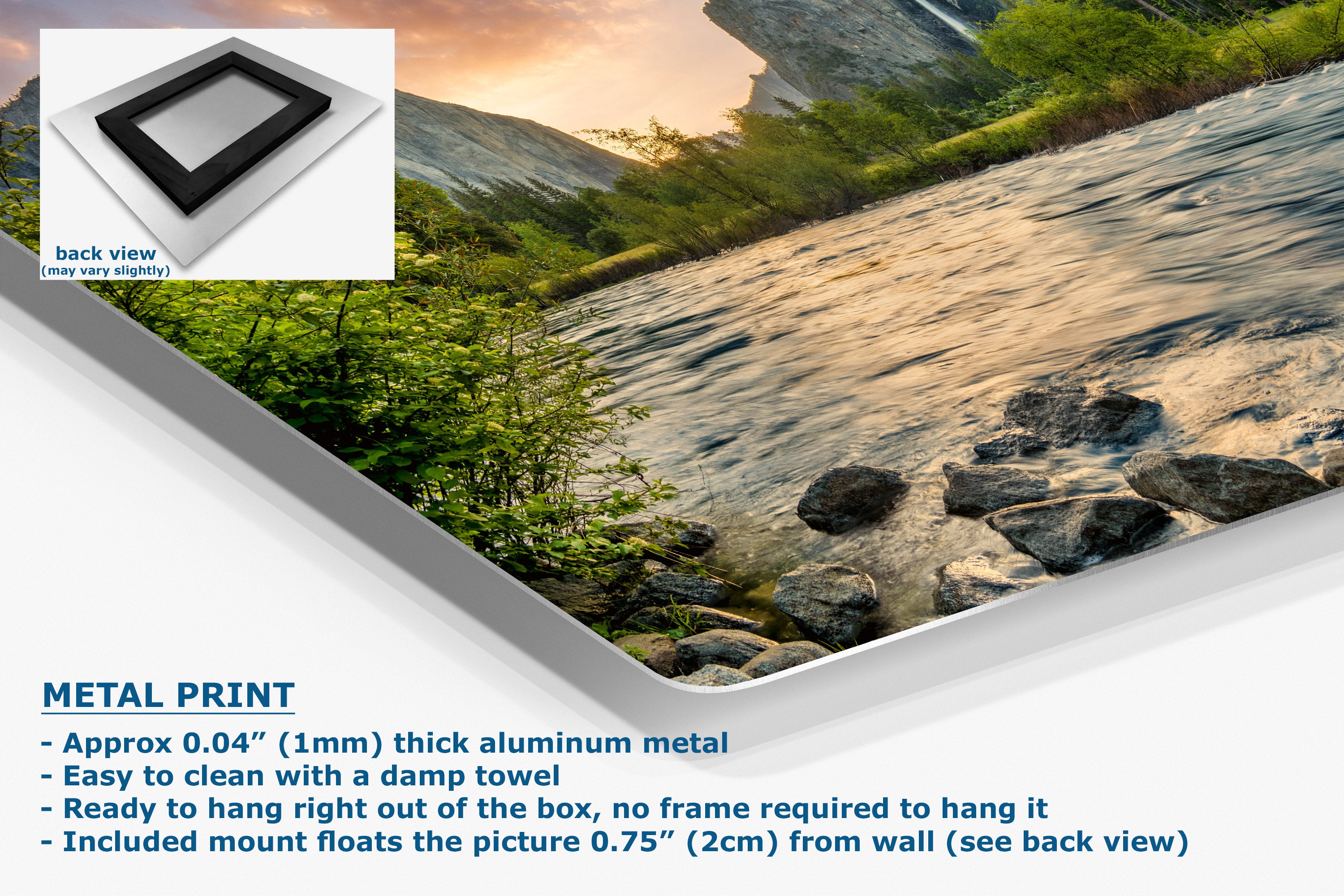 A metal wall art print showing a mountain stream scene with rocks, greenery, and warm sunset light, presented at an angle with a white corner fold.