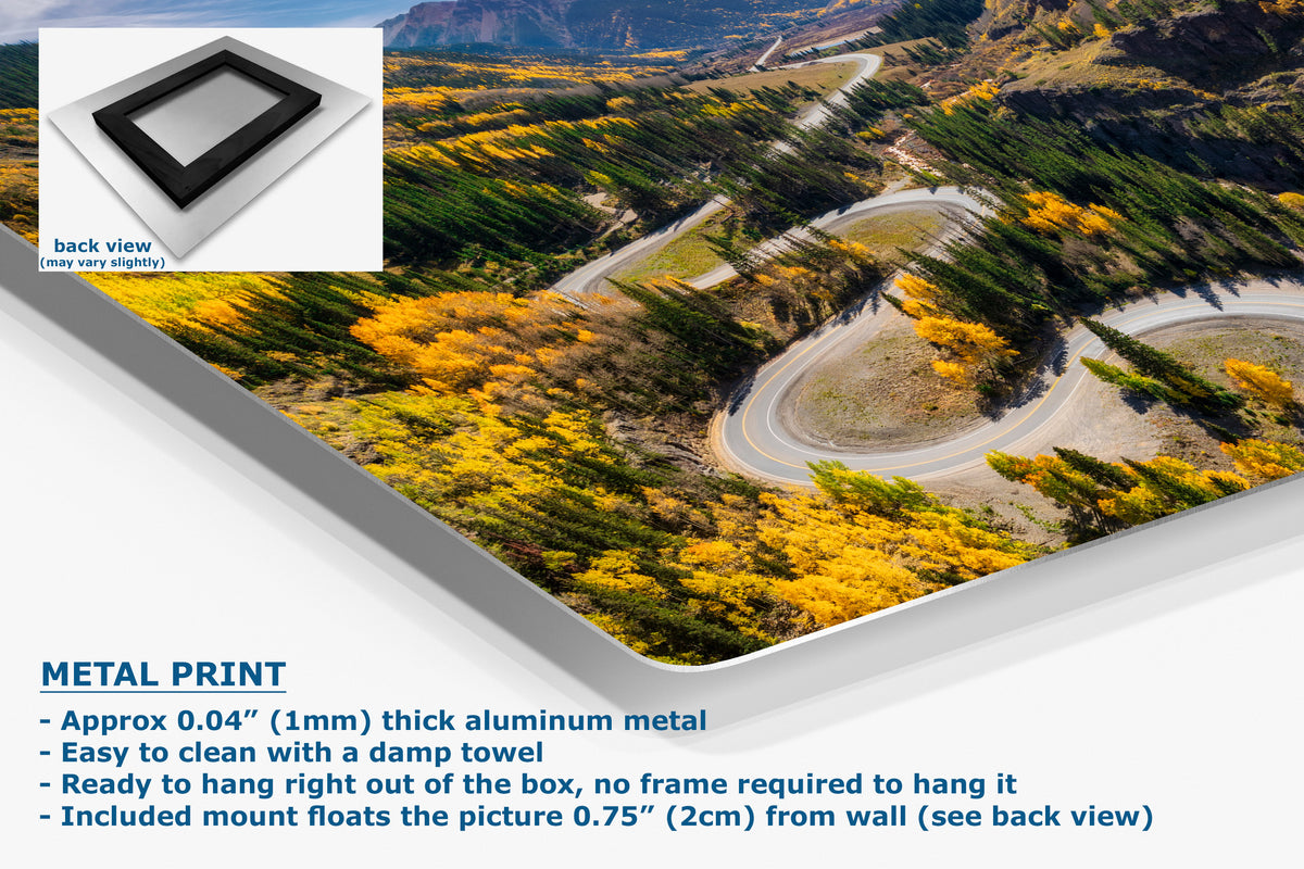 A corner view of an aluminum metal print panel shown at an angle, featuring a scenic aerial photograph of a winding road through yellow autumn trees and mountains. The image includes a small inset showing the back view of the panel, plus text describing the product as a metal print with thickness and hanging details.