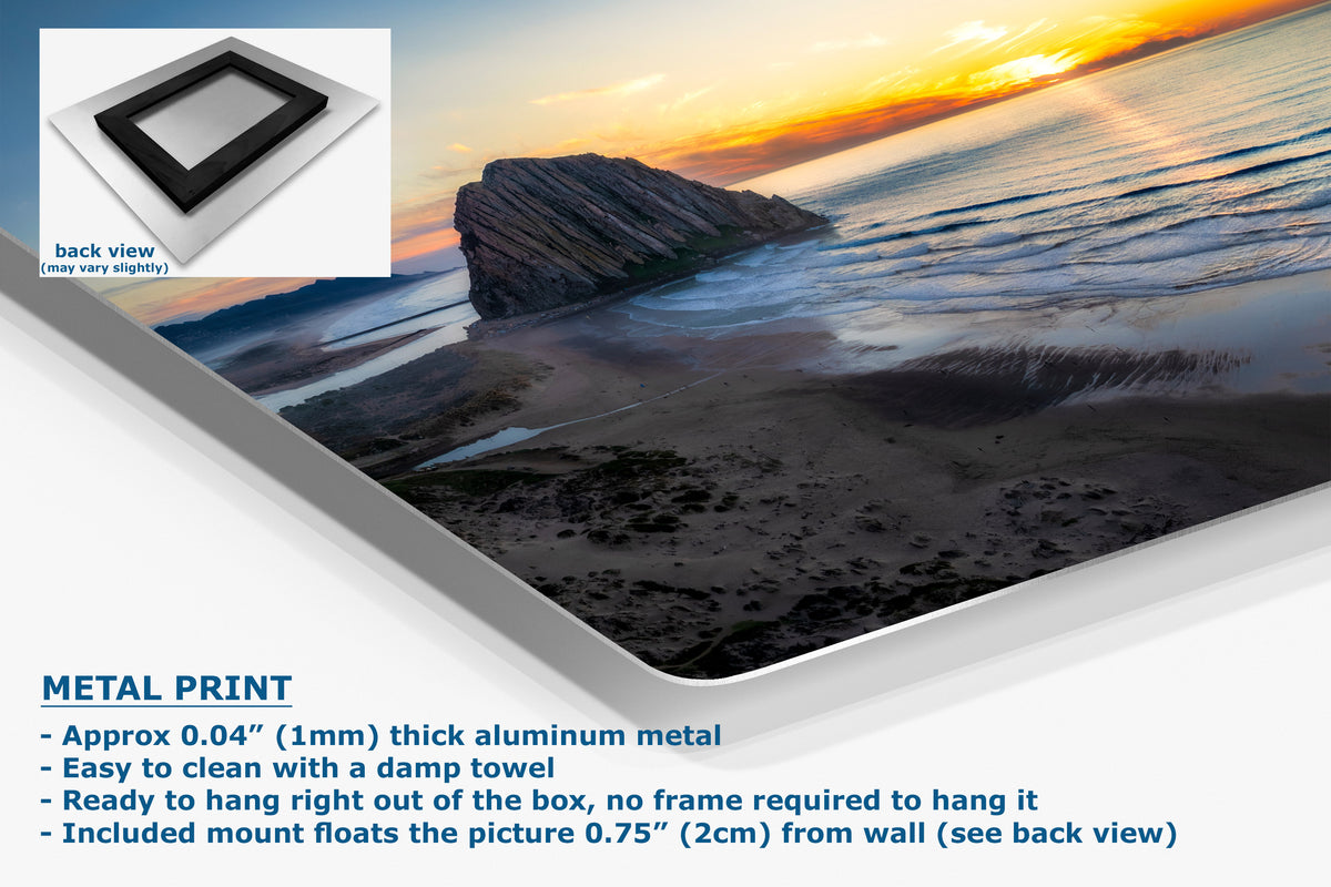 A metal print poster of a rocky beach at sunset, shown at an angle with text detailing its aluminum construction and mounting features, plus a small back-view inset.