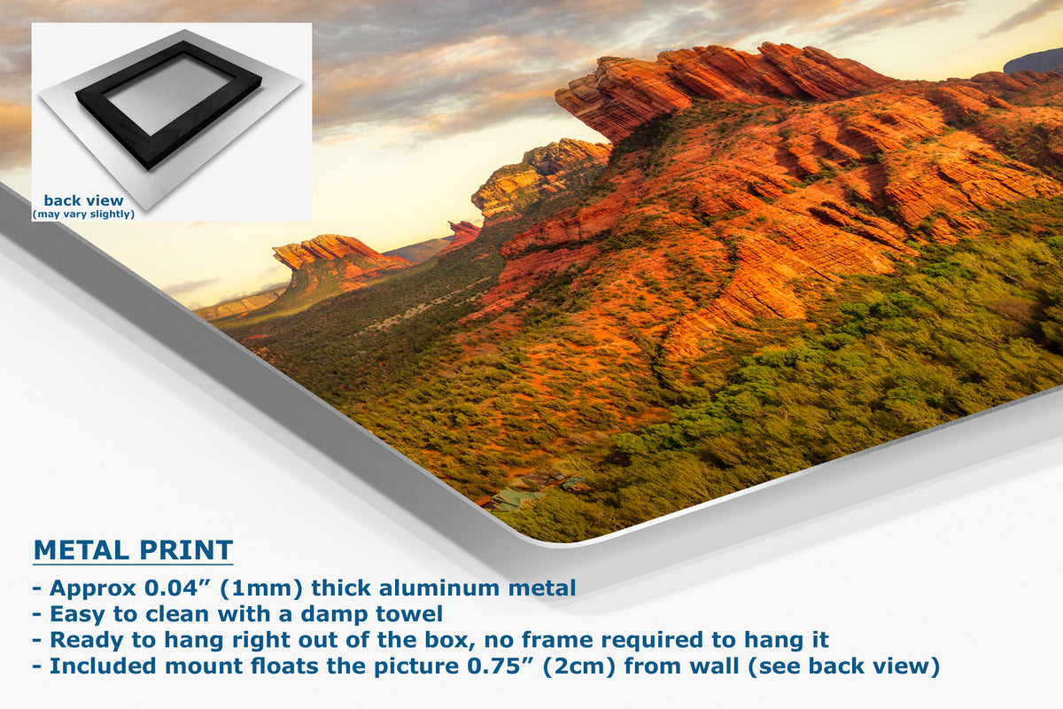A metal wall art print showing a desert canyon landscape, presented at an angle with text describing its aluminum finish and mounting features. A small inset shows the back view of the frameless print.