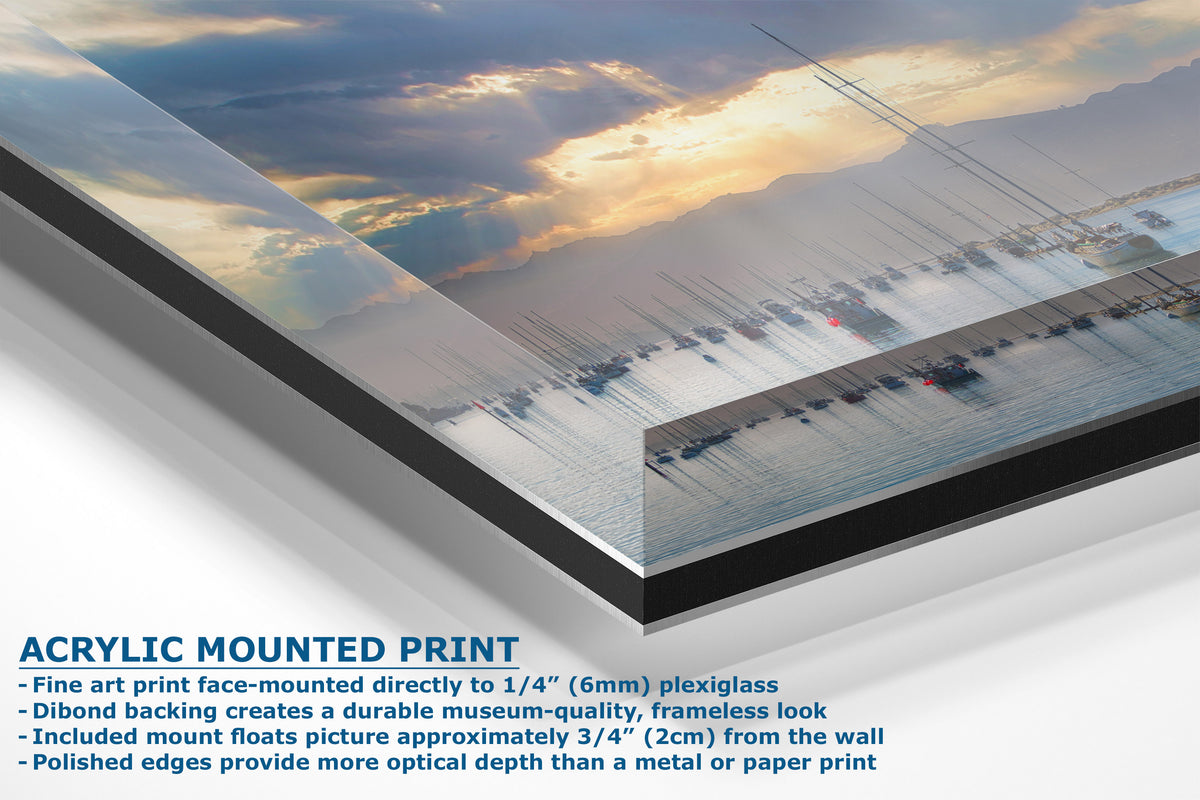 Acrylic mounted art print panel showing a scenic sunset over water with boats, with descriptive text on the left detailing the mounting features.