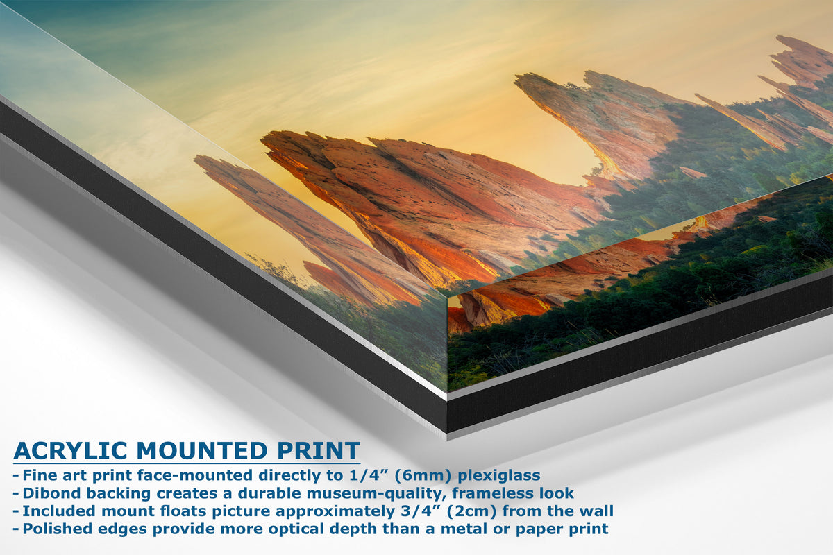A corner view of an acrylic-mounted art print of a desert canyon landscape, showing the angled edge of the print with text detailing its features on a white background.
