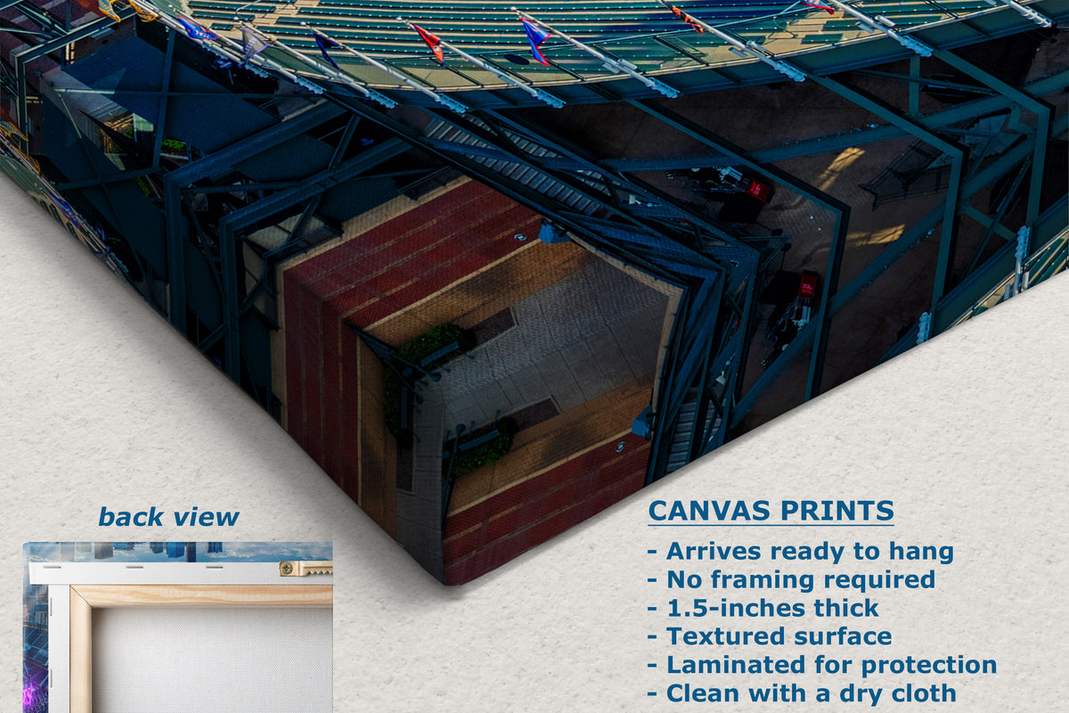 A corner view of a canvas wall art print shown at an angle with a text callout describing features and a small inset labeled back view. The artwork depicts a stadium-like scene with blue seating, green field elements, and a reddish-brown central structure.