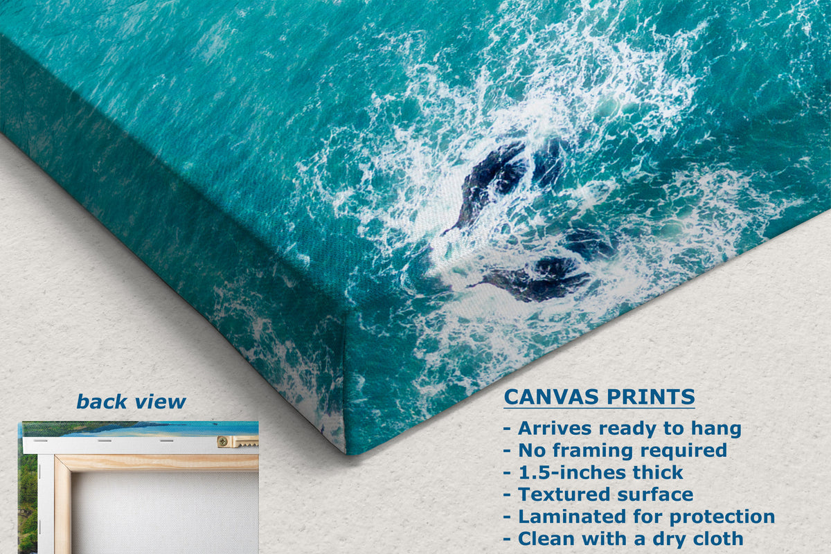 A corner view of a canvas wall art print showing a close-up of ocean waves, displayed at an angle on a light wall. Text on the image describes the canvas print features, and a small inset shows the back view with a frame.