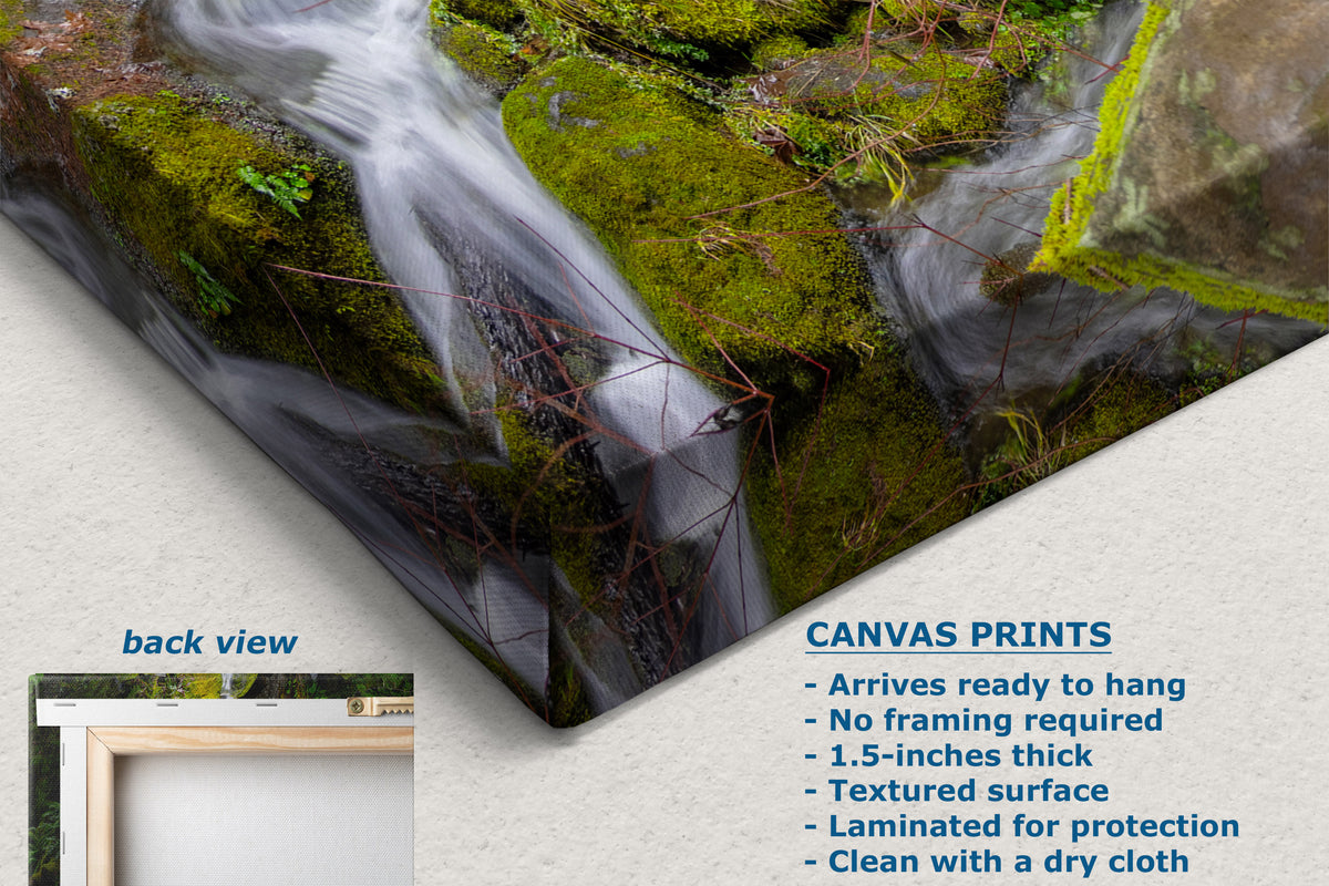 Canvas wall art print showing a waterfall flowing over mossy rocks, displayed at an angle with a small inset labeled 'back view' and text describing the canvas print features.
