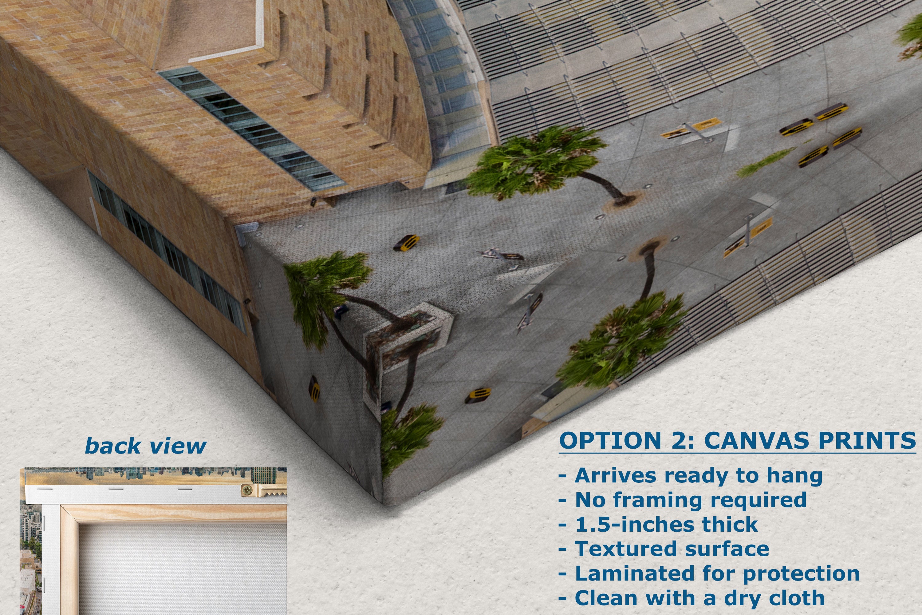 A printed canvas wall art print shown at an angle, displaying a detailed architectural scene of a modern building with a plaza and palm trees. The image includes text overlays detailing product features for canvas prints and a small inset showing the back view of the print.