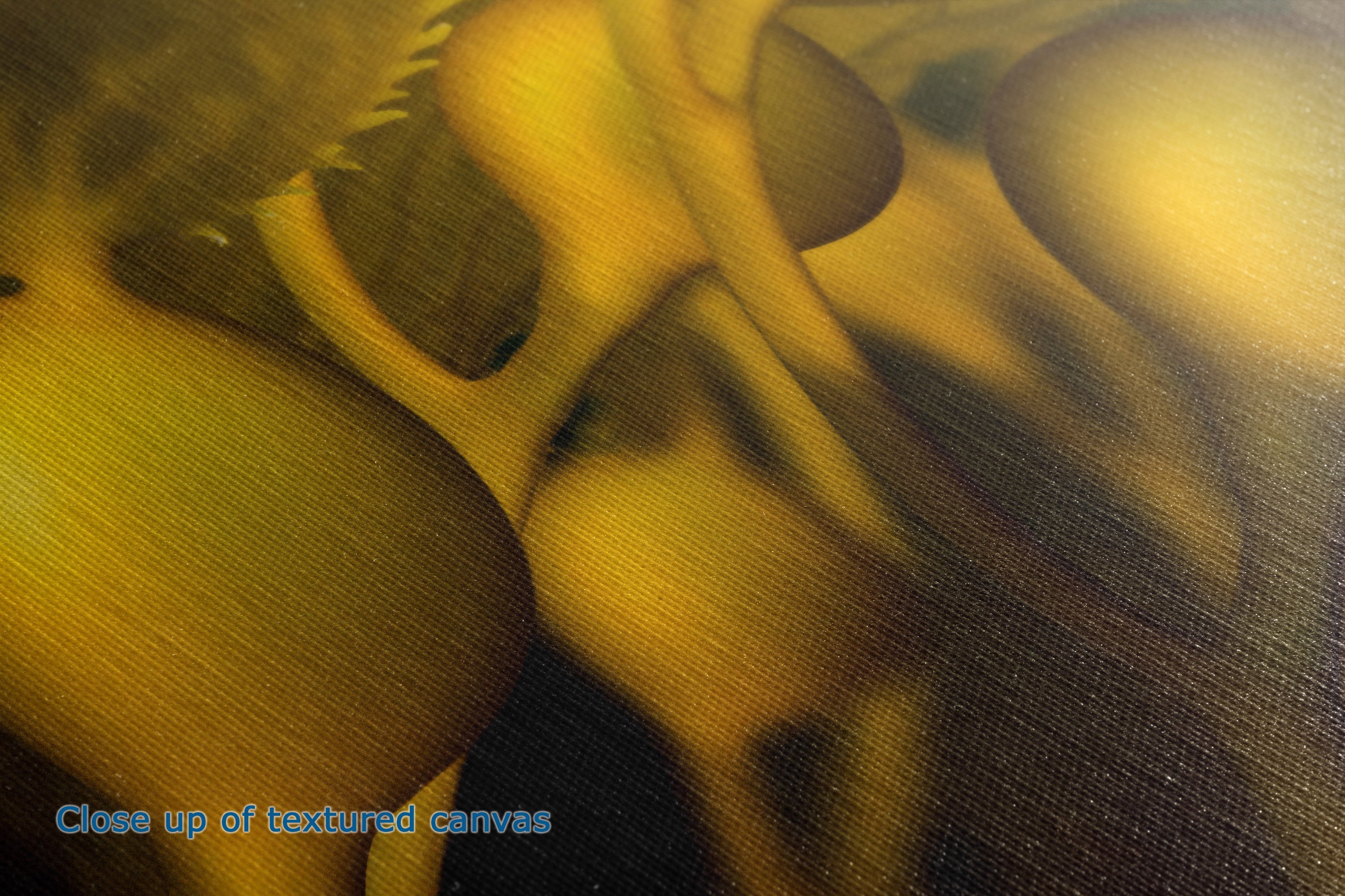Close-up of a textured canvas print featuring abstract organic shapes in warm golden yellow, olive green, and dark brown tones, with blue text in the lower-left corner reading 'Close up of textured canvas'.