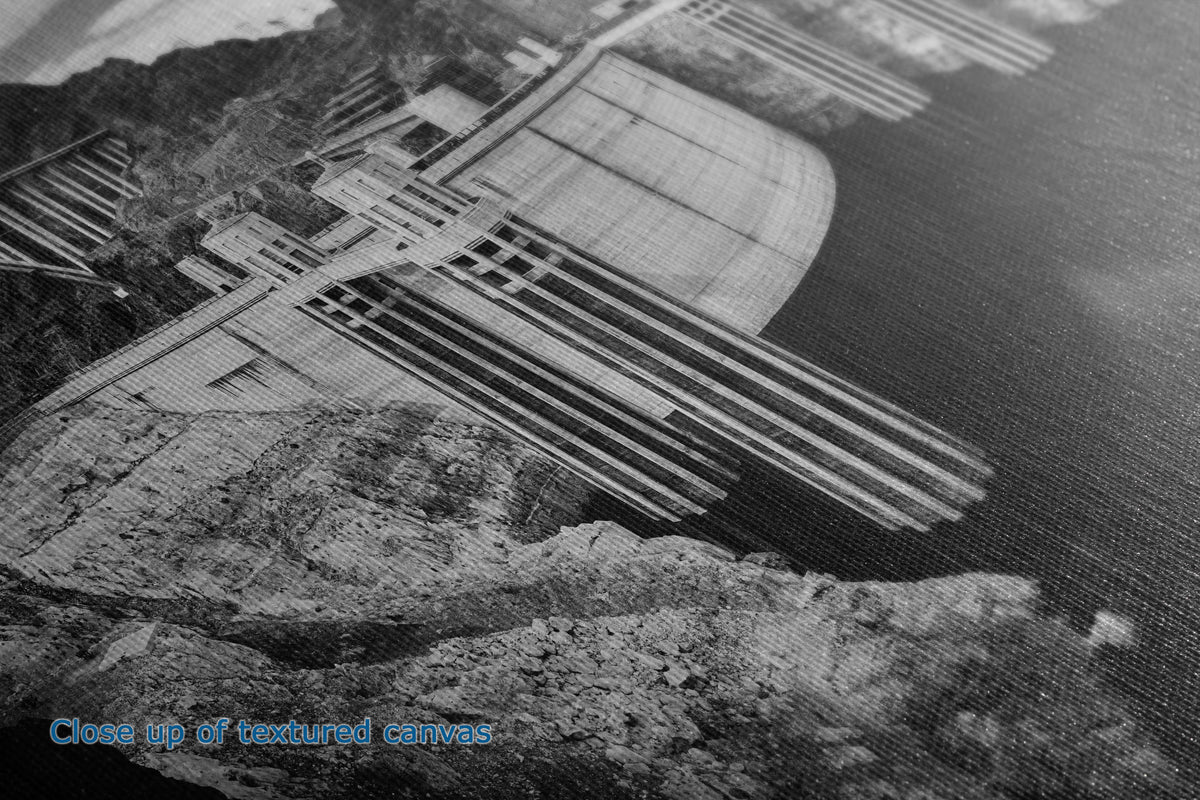 Black and white close-up of a textured canvas print depicting a dam and canyon landscape, with blue text in the lower-left corner reading 'Close up of textured canvas'.