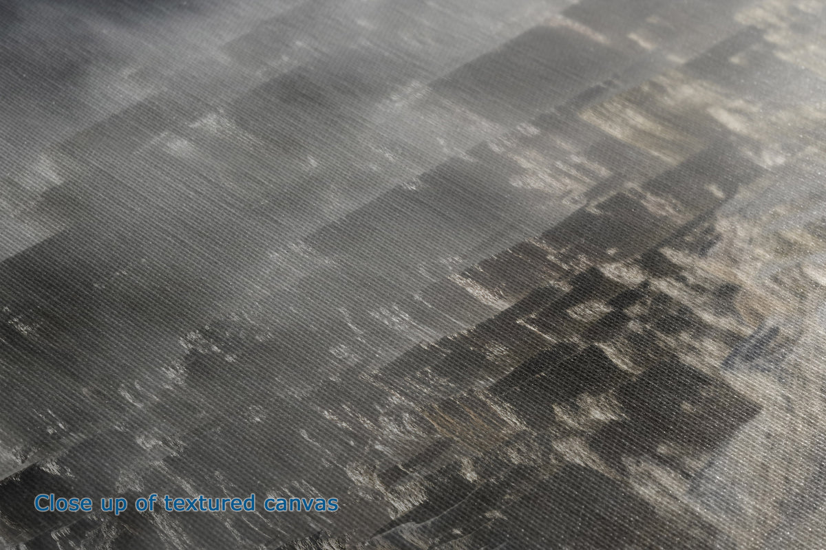 Close-up of the detail and texture of a canvas surface with a mottled gray, black, and off-white pattern, showing the woven fabric detail.