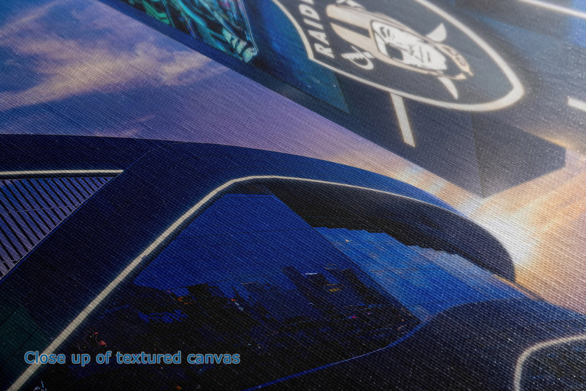 Close-up of the detail and texture of a  canvas print featuring a dark blue and black graphic design with a white outlined logo and a city skyline at sunset. The text 'Close up of textured canvas' appears in the bottom-left corner.