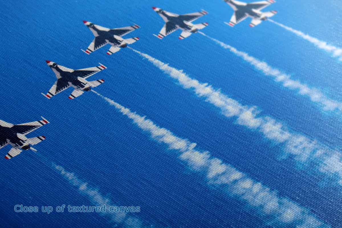 Close-up of the detail and texture of a canvas print depicting four fighter jets flying in formation against a bright blue sky, leaving white contrails.