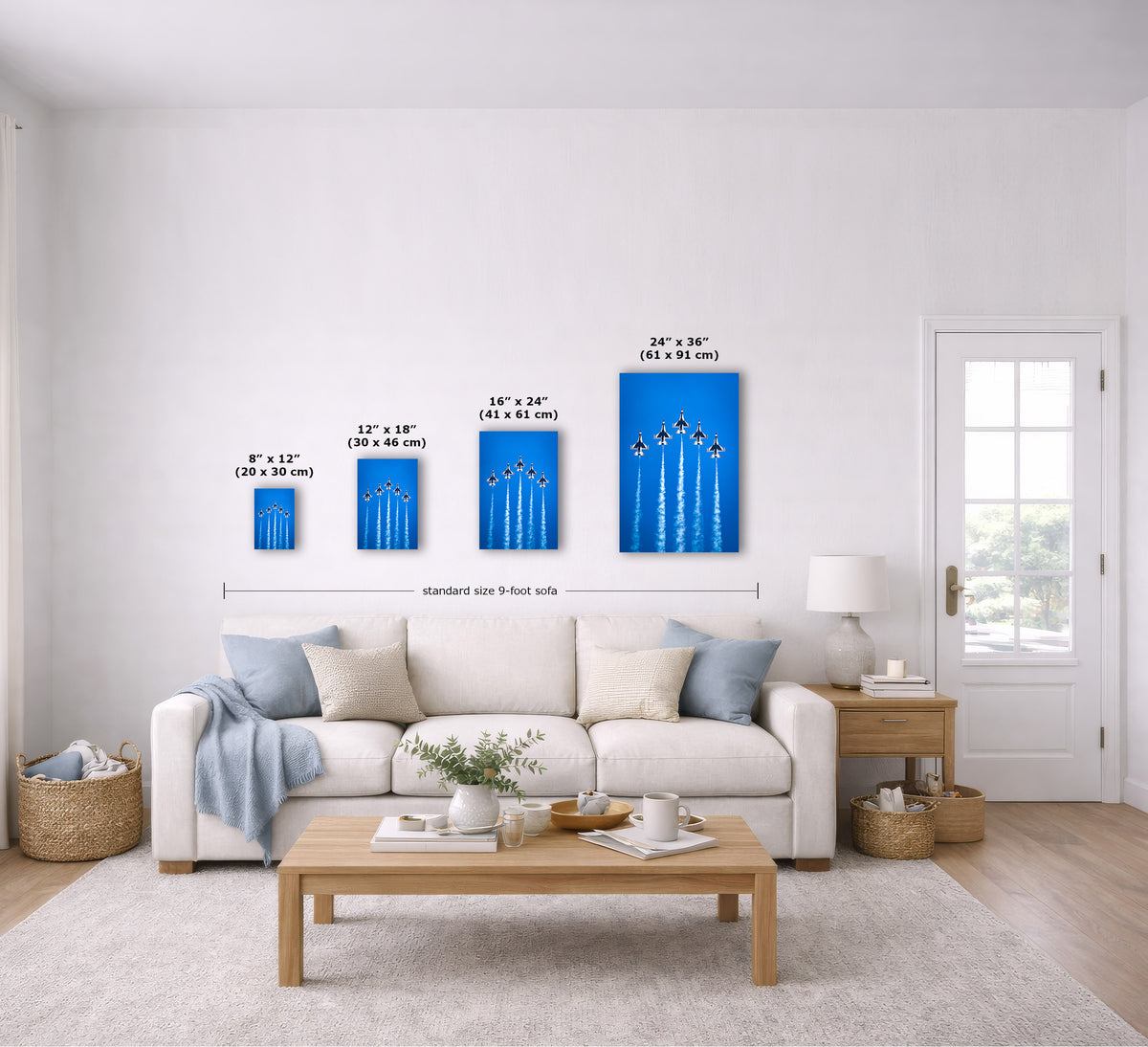 A staged living room shows a set of four vertical blue wall art prints with white line illustrations, each labeled with dimensions. The prints are displayed above a white sofa, with measurement arrows and text indicating sizes from 8"x12" to 24"x36".