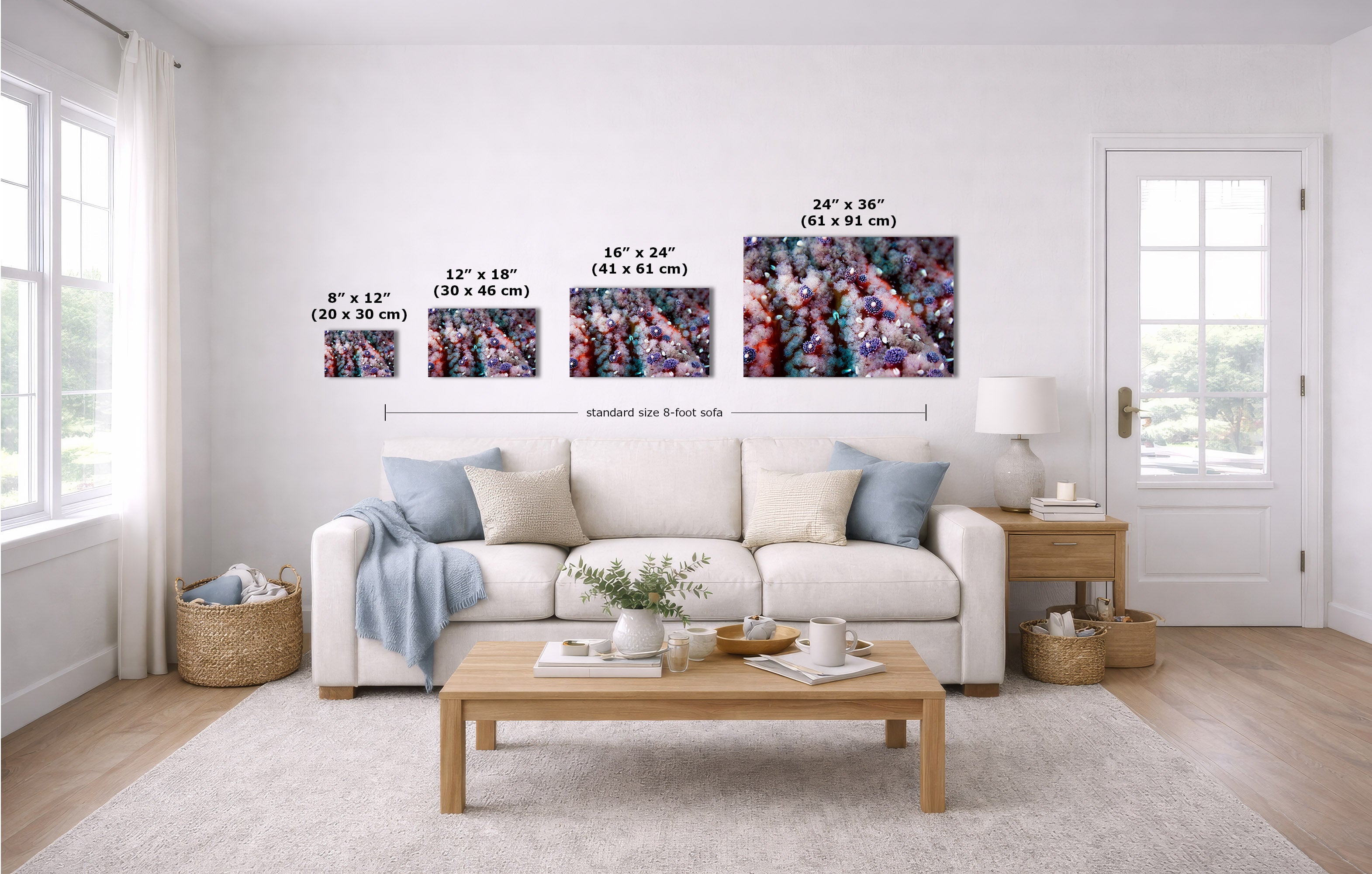A staged living room shows four wall art prints above a white sofa, with size labels and arrows indicating dimensions. Because a real interior environment is present, this is a lifestyle image rather than a measurement chart, even though size information is overlaid.