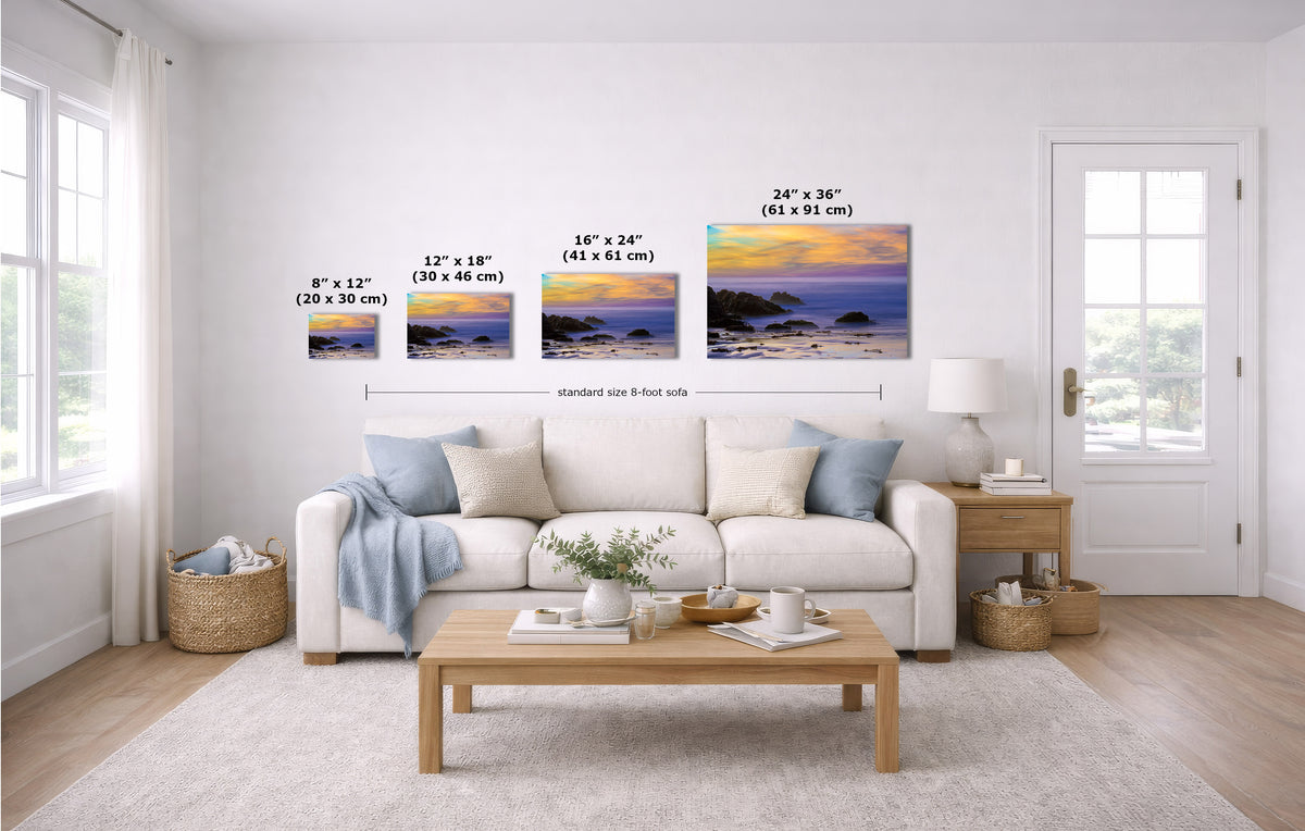 A staged living room with a white sofa, coffee table, and wall-mounted framed art. The product being shown is the set of four landscape wall prints, each labeled with dimensions (8 x 12, 12 x 18, 16 x 24, 24 x 36 inches).