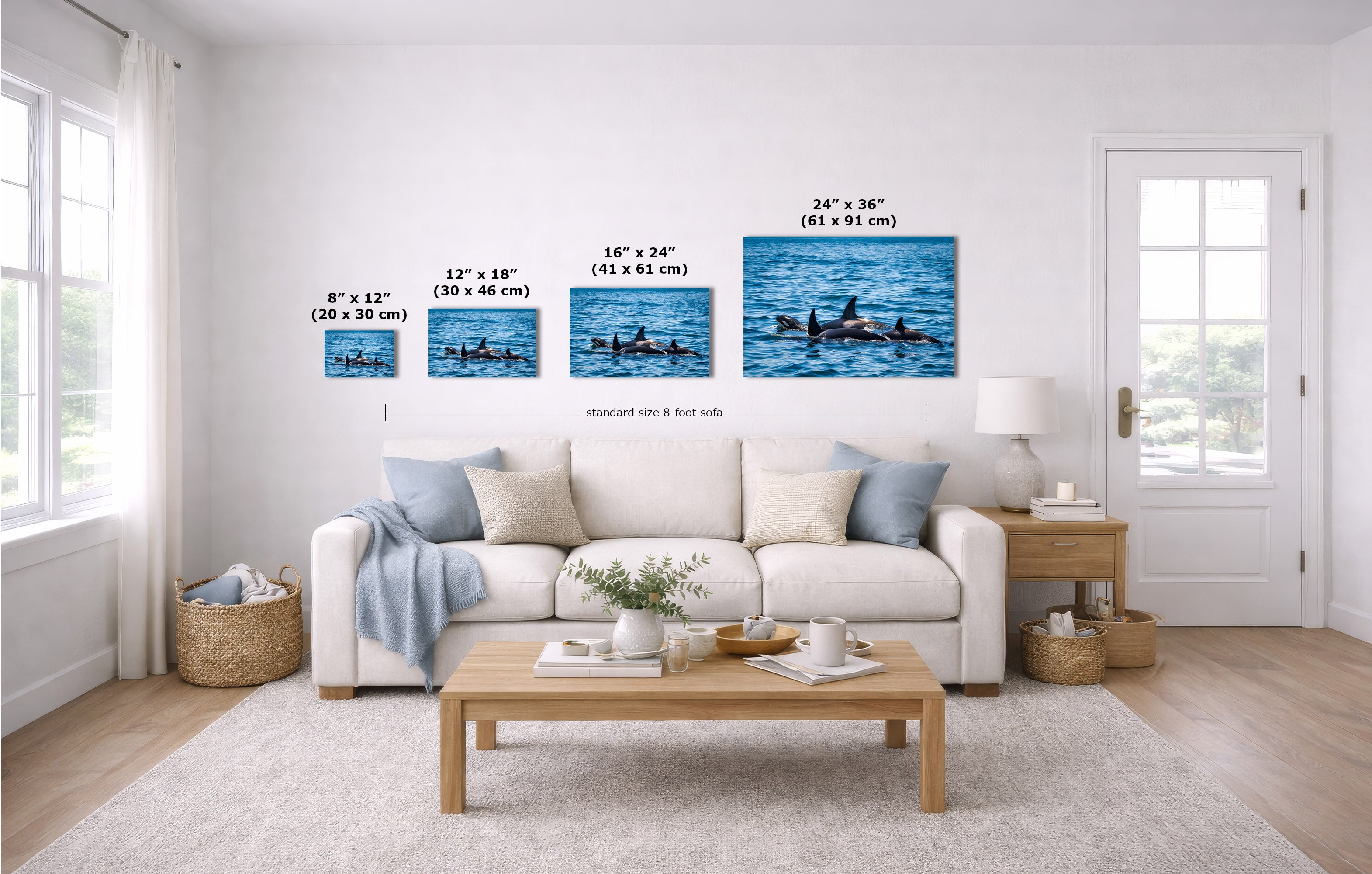 A staged living room shows four wall art prints above a white sofa, each with overlaid size labels in inches and centimeters. The prints depict blue water scenes with dark figures on the water.