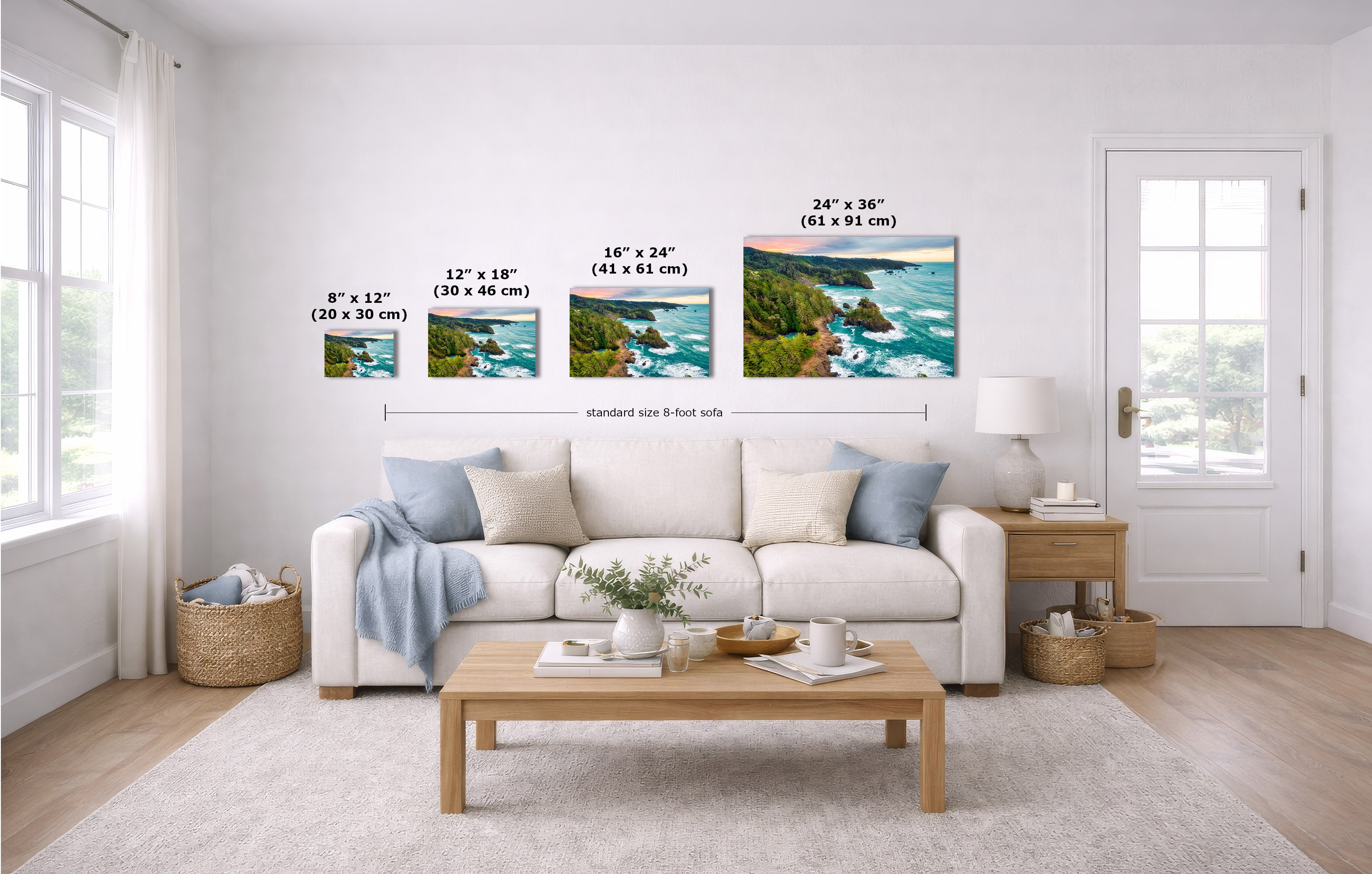 A staged living room with a white sofa, coffee table, and wall-mounted coastal landscape prints. Black measurement lines and text labels show the dimensions of four wall art sizes relative to an 8-foot wall.