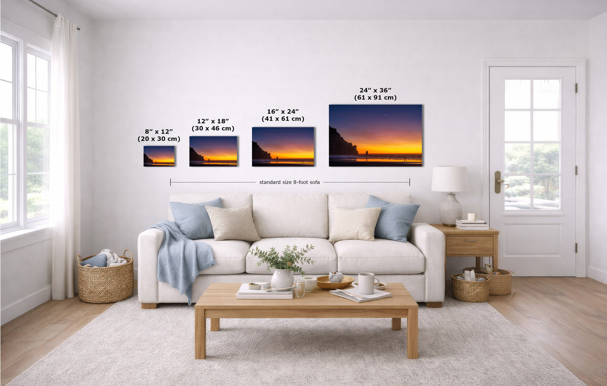 A staged living room shows four wall art prints above a white sofa, each with size text labels. The prints depict a dramatic orange and yellow sunset over dark water.