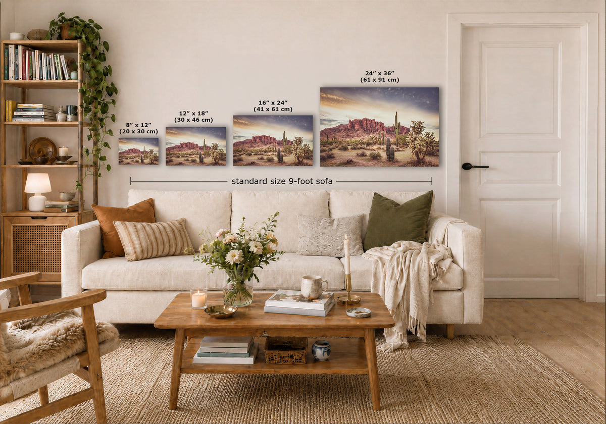 A staged living room shows a white sofa, wooden coffee table, shelving, and a large wall display of four framed desert landscape prints with printed size labels and a dimension line reading standard size 9-foot sofa.
