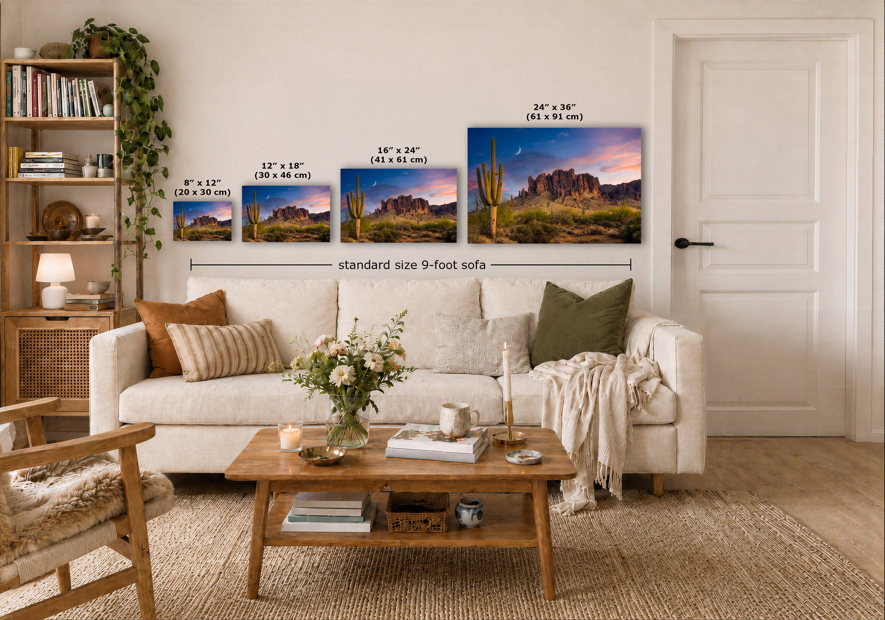Three desert landscape wall art prints are displayed above a white sofa in a styled living room. The prints show different sizes of the same scenic artwork with cacti and rock formations under a purple and pink sky.