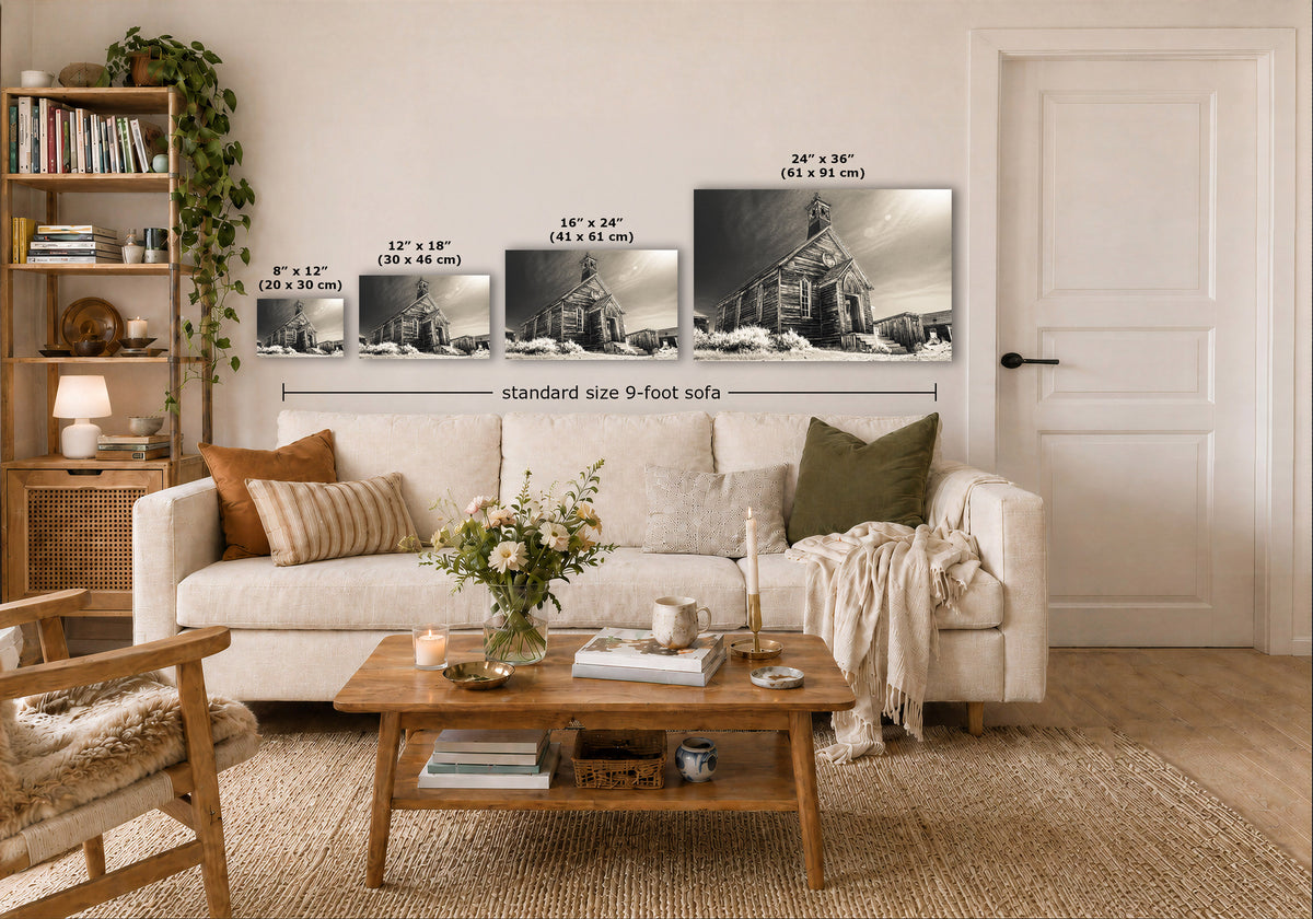 A styled living room showing a set of four sepia wall art prints depicting a church building, with size labels and a dimension line across the prints. The prints are displayed above a white sofa in a warm, modern interior.