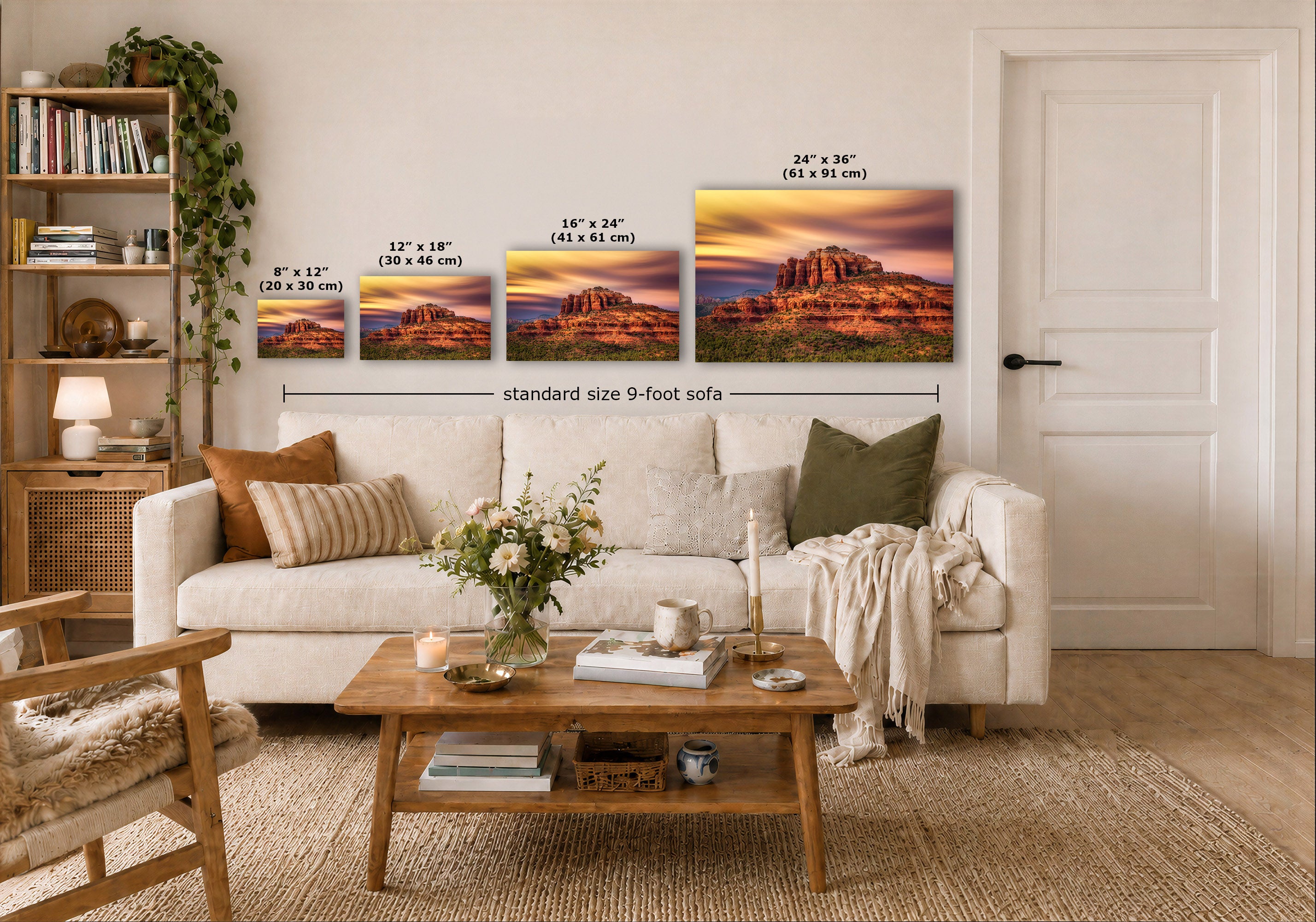 A staged living room shows a white sofa, wooden coffee table, shelving, and four wall-mounted landscape art prints with printed size labels. 