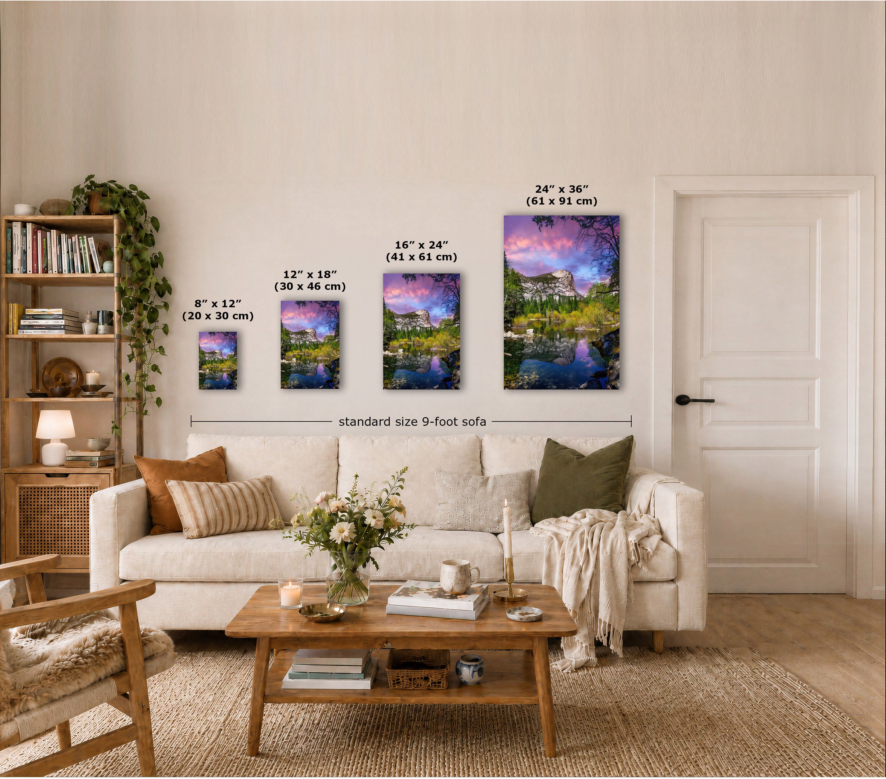 Four vertical landscape canvas prints in different sizes displayed on a beige wall above a white sofa in a styled living room. Each canvas shows a colorful scenic painting with water, trees, and sky.