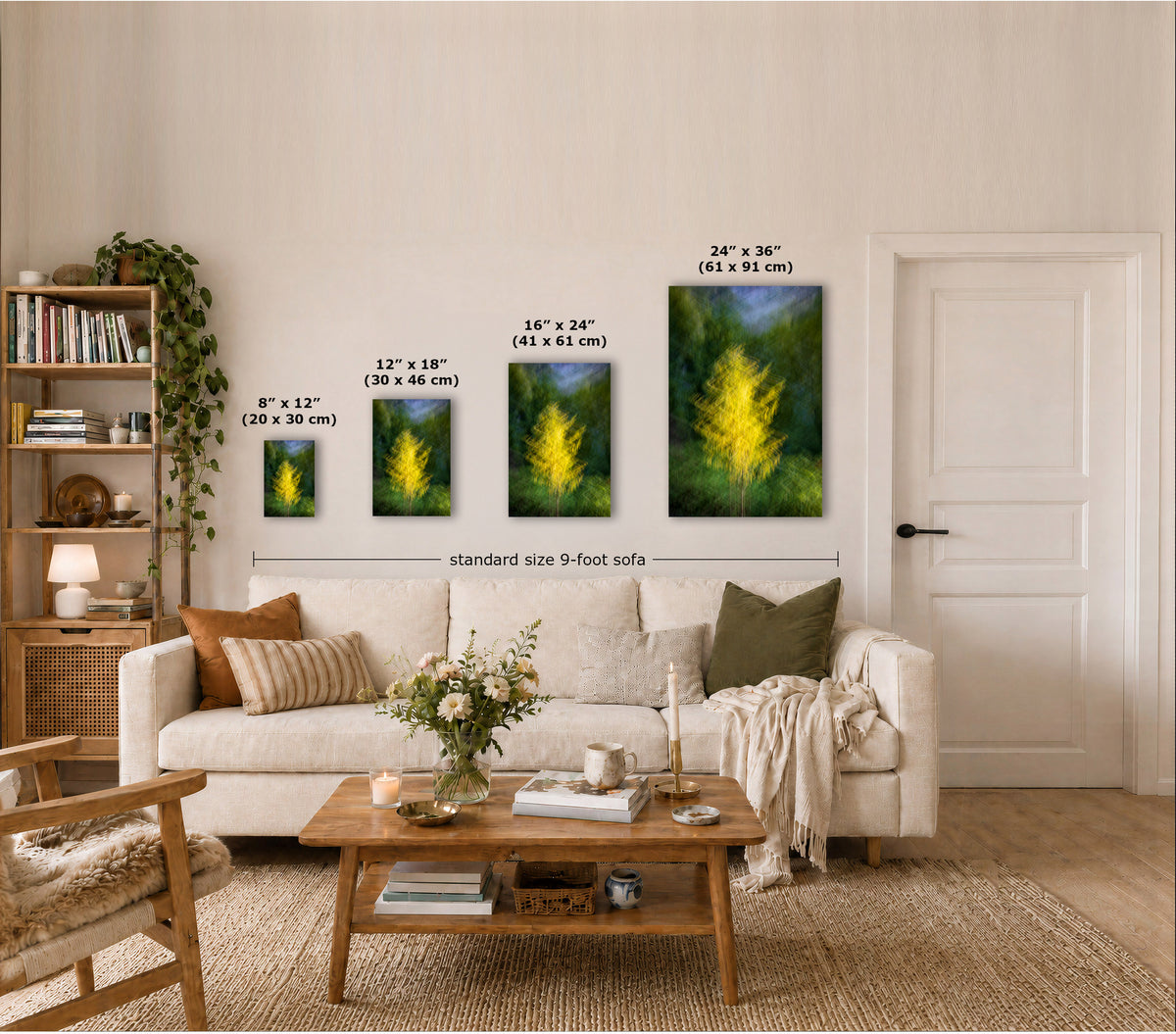 A staged living room shows four vertical wall art prints with yellow grass artwork, each labeled with dimensions. The room includes a cream sofa, wooden coffee table, bookshelf, and a size annotation comparing the prints to a standard 9-foot sofa.