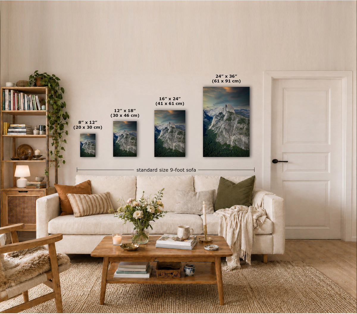 A styled living room showing four vertical wall art prints of mountain landscapes in different sizes above a cream sofa, with overlaid dimensions for each print and a note reading 'standard size 9-foot sofa'.
