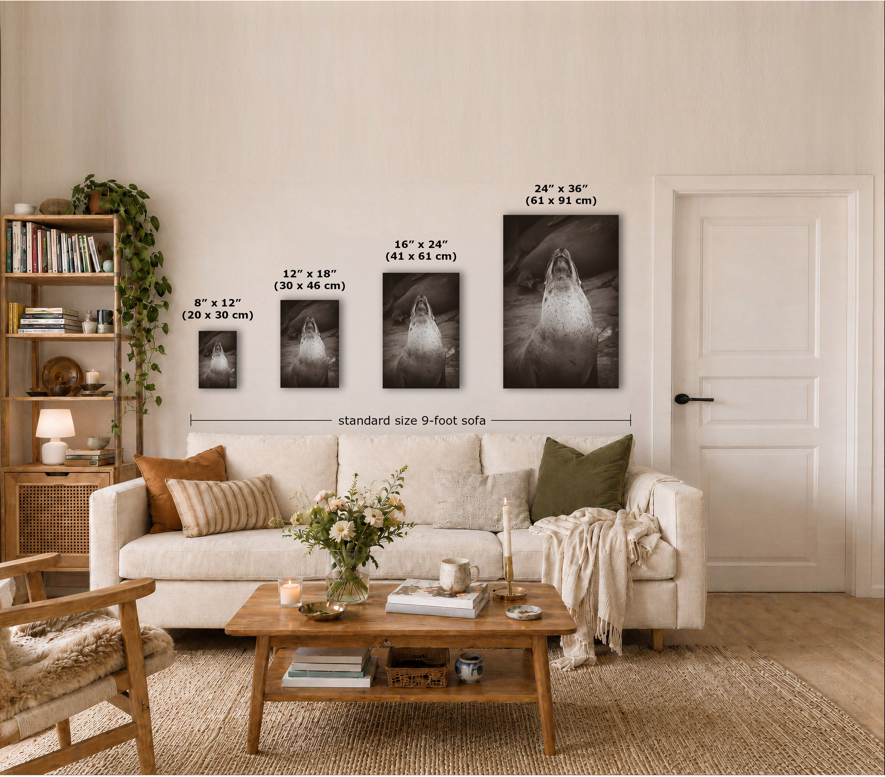 A styled living room showing four framed black-and-white wall art prints of different sizes mounted above a sofa, with size labels overlaid on each print and a dimension line across the set. The room includes a cream sofa, wooden coffee table, shelving, and a white door.