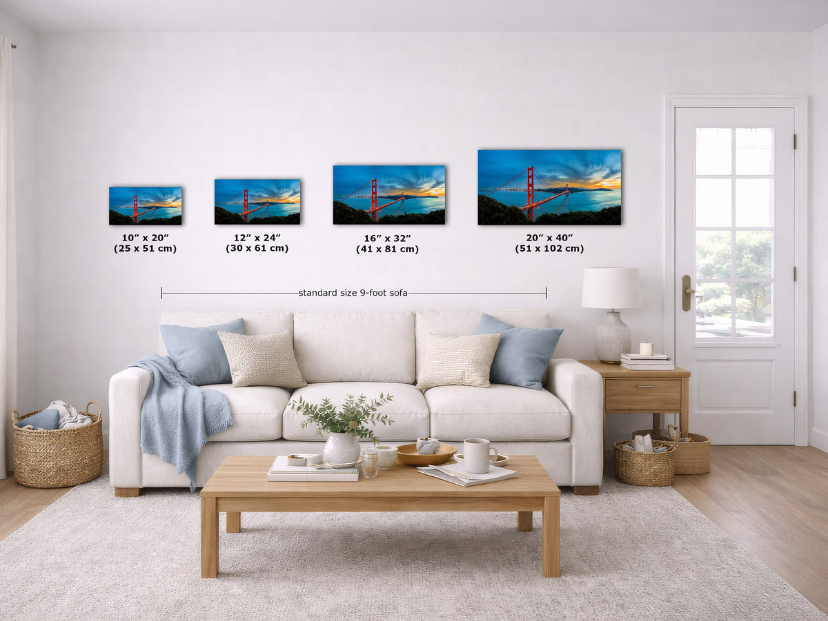 A staged living room shows four framed wall art prints above a white sofa, each labeled with dimensions. The prints depict a golden bridge sunset scene.
