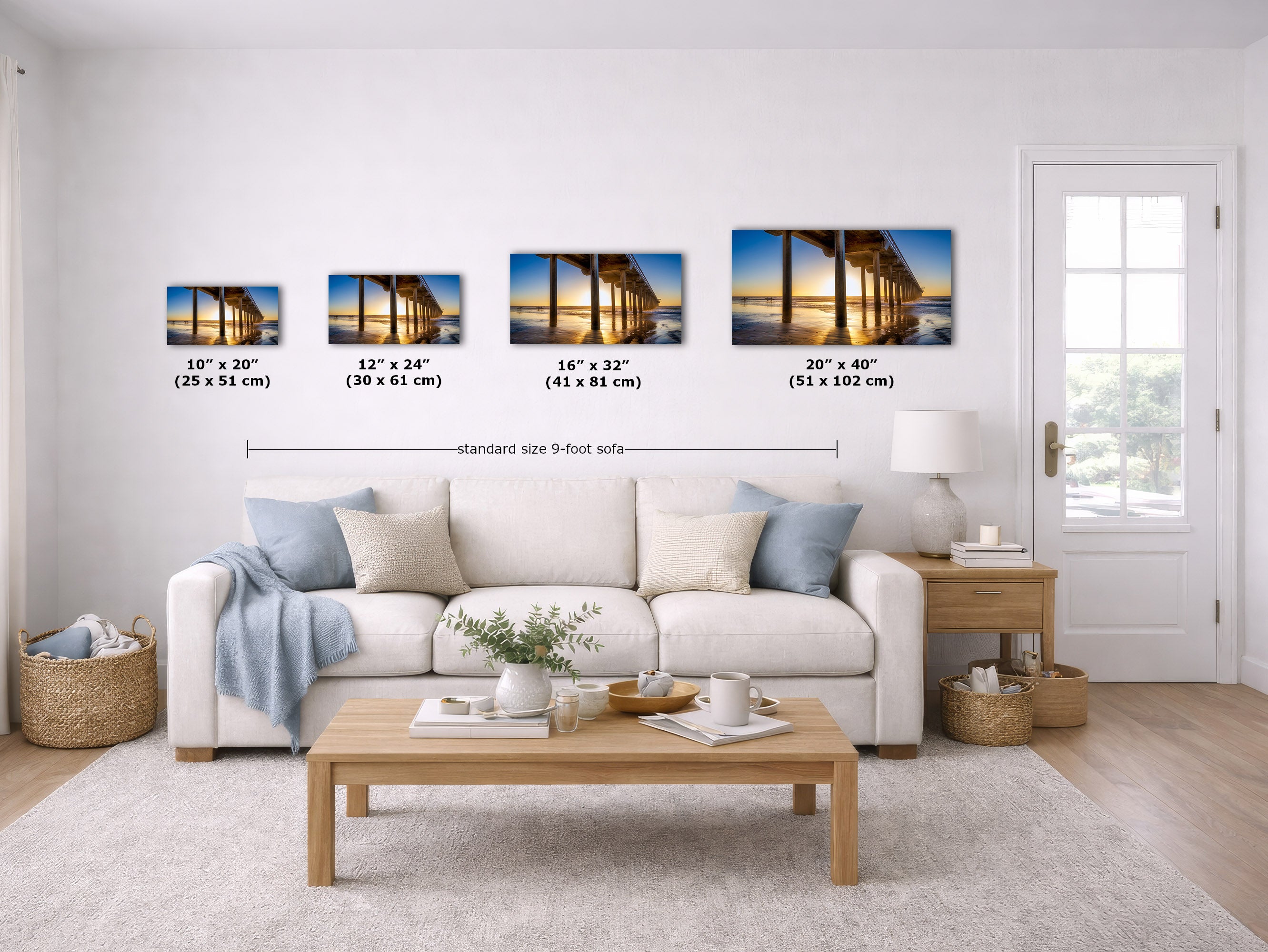 A staged living room shows four wall art prints above a sofa, each with size text labels underneath. The prints depict a bridge or pier scene at sunset.