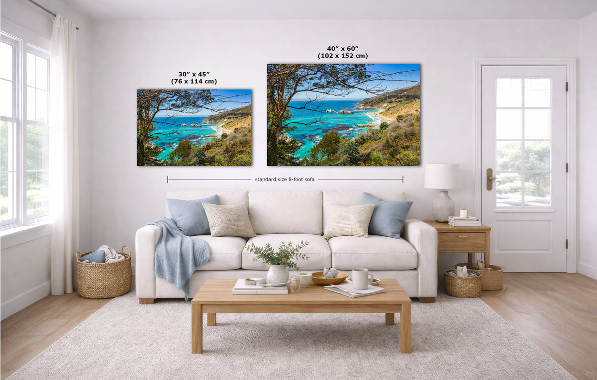 A staged living room shows two California coastal landscape wall art prints above a white sofa. The left print is labeled 30 x 45 inches, and the right print is labeled 40 x 60 inches.