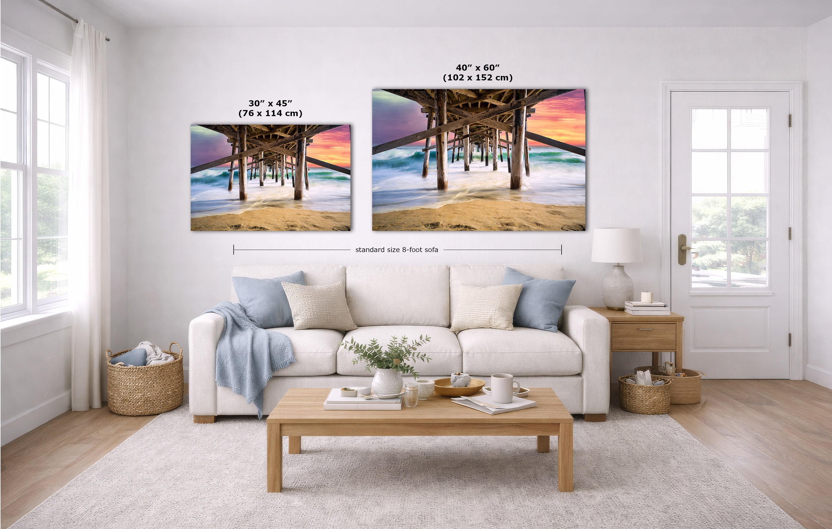 A staged living room with a white sofa, coffee table, and two beach pier artwork prints on the wall. The prints show sunset colors and include size callouts: 30 x 45 inches and 40 x 60 inches, with a dimension line labeled standard size 8 feet side.