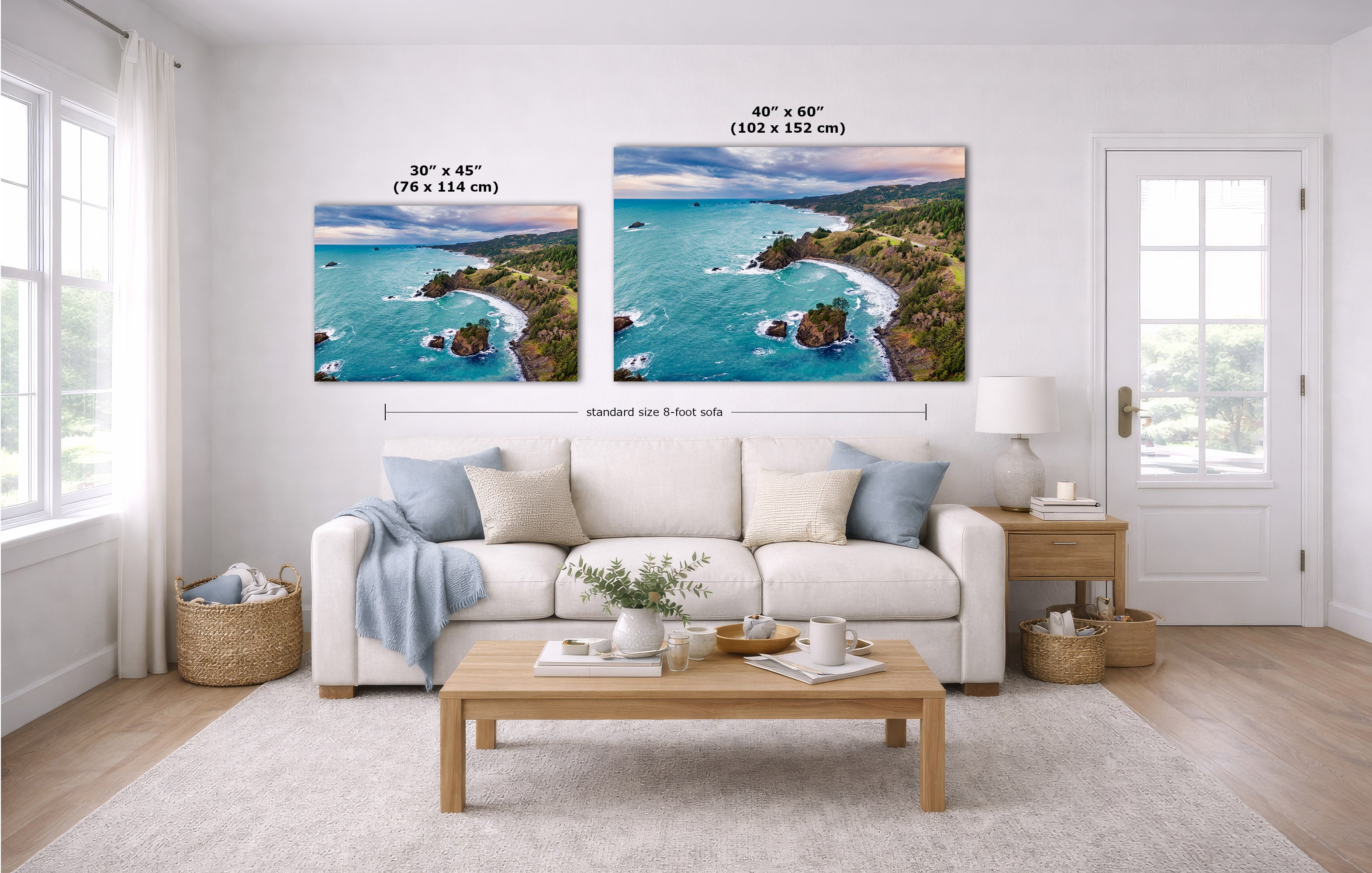 A staged living room shows two coastal landscape wall art prints above a white sofa, with size callouts reading 30 x 45 inches and 40 x 60 inches. The room includes a light wood coffee table, white rug, side table, lamp, baskets, and a white door.