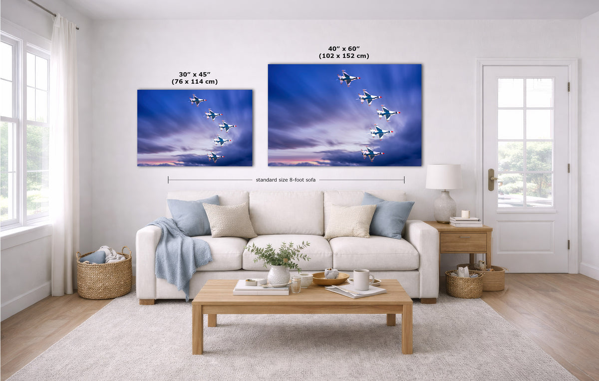 Two wall art prints showing blue sky and flying jets hang above a white sofa in a bright living room. Measurement labels and dimensions are overlaid on the prints.