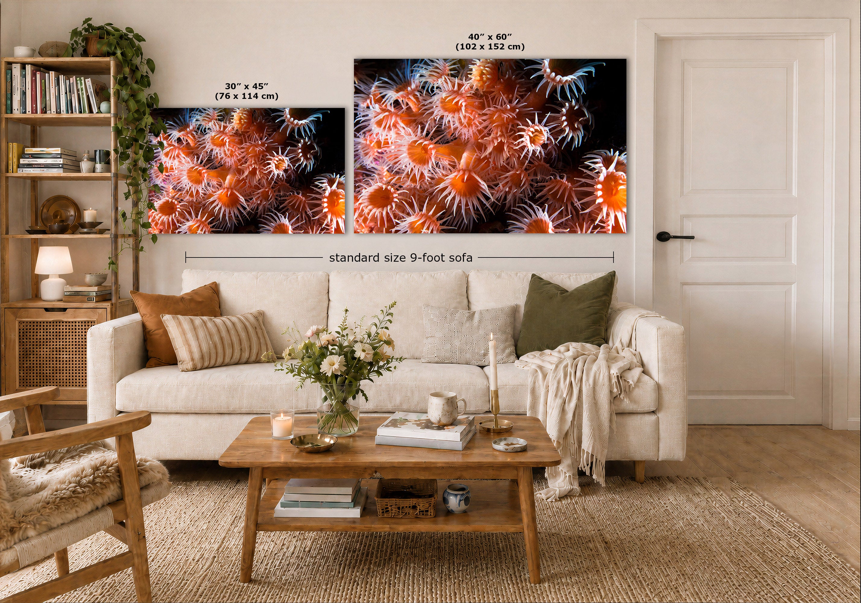 A styled living room showing two large wall art prints with fish-reef style artwork in orange, red, and black. The prints are displayed above a white sofa, with size labels overlaid: 30 x 45 inches for the smaller print and 40 x 60 inches for the larger print.