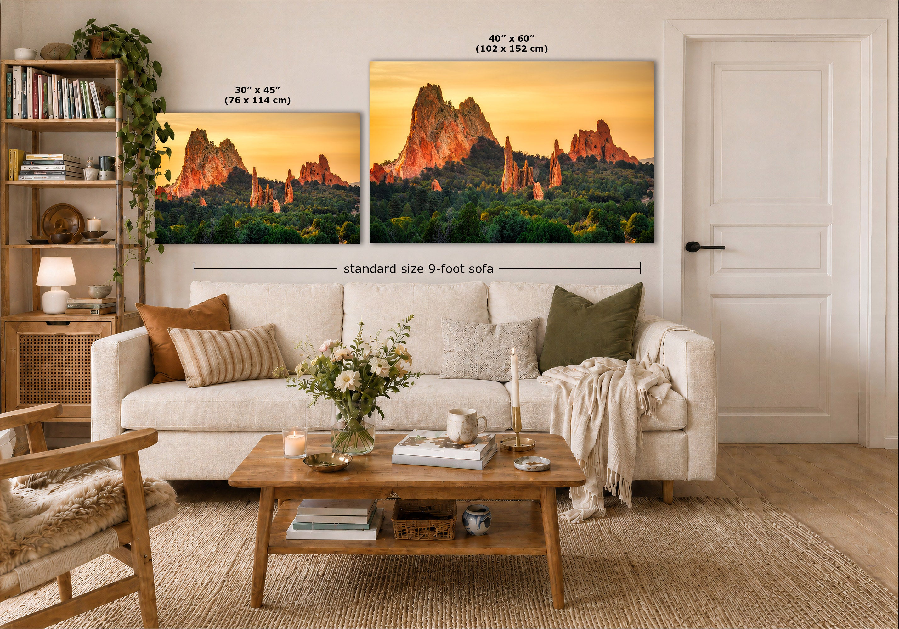 A styled living room showing two landscape wall art prints above a white sofa. The prints depict a warm sunset over jagged rock formations with green forest below.