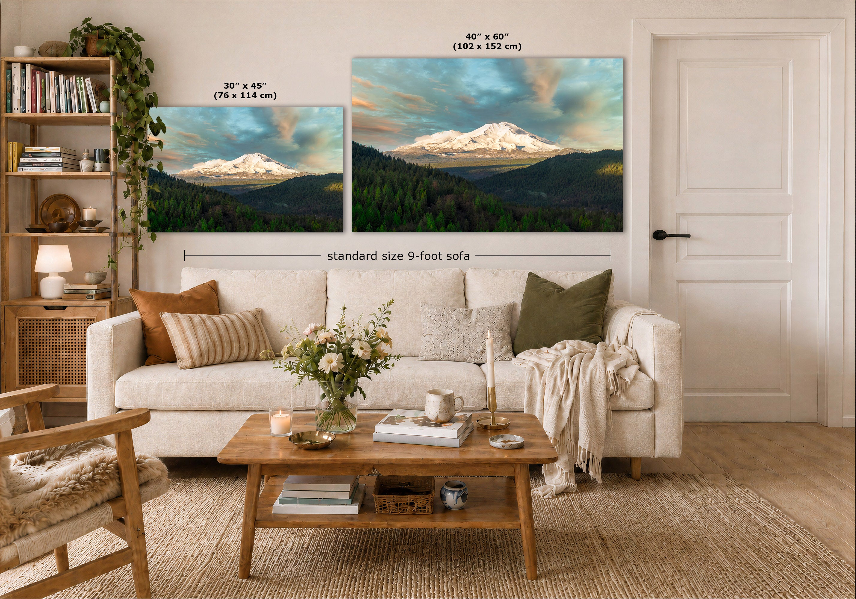 A styled living room showing two large wall art prints above a white sofa. The prints depict snow-capped mountains over dark green forest under a blue sky.